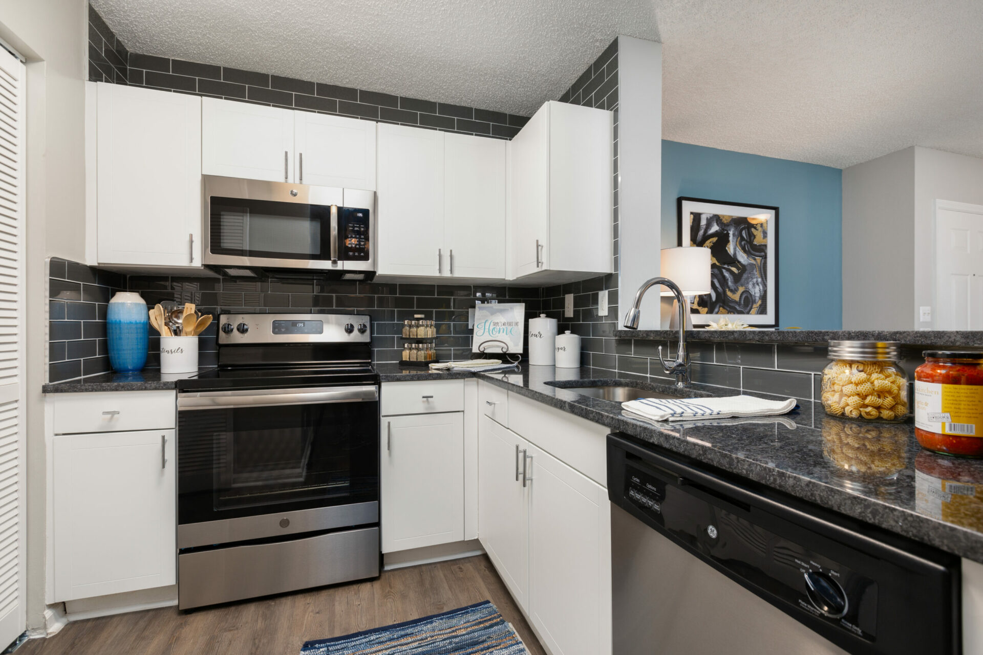 Kitchen with stainless steel appliances and white cabinets in an apartment at Beach Walk at Sheridan.