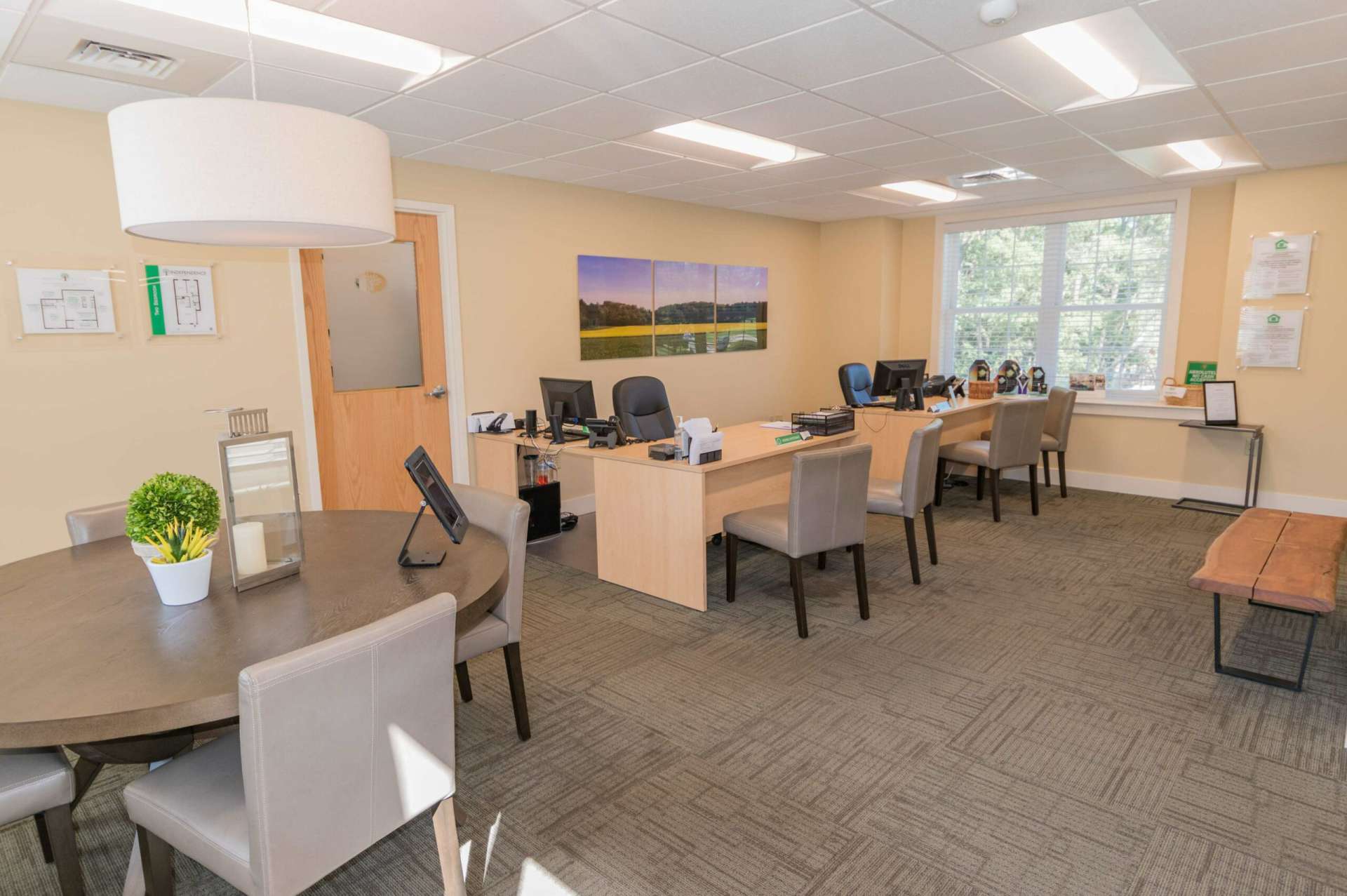 Leasing office with two office desks and a circular table.