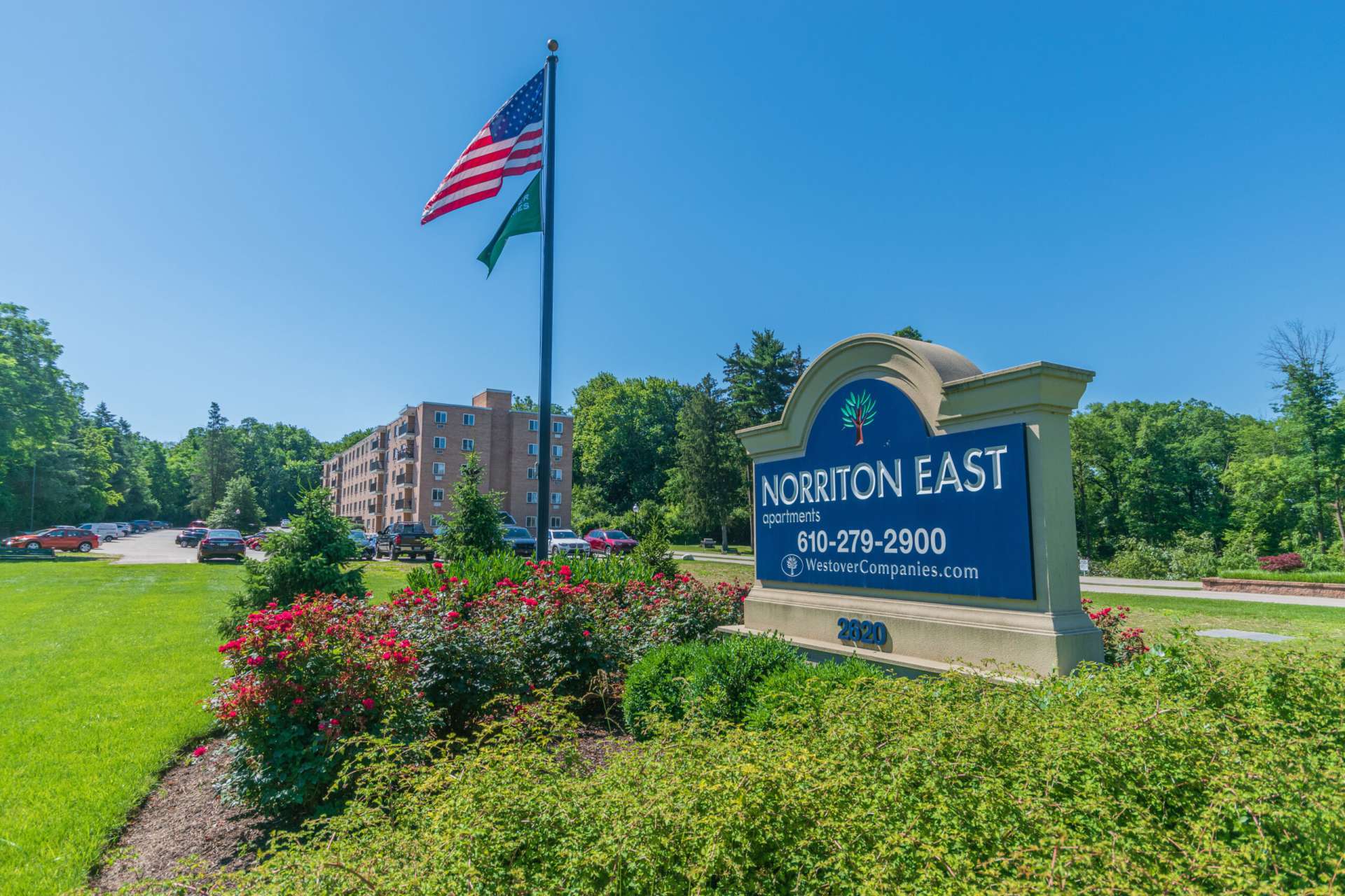 Norriton East Apartments sign with a variety of plants and bushes.