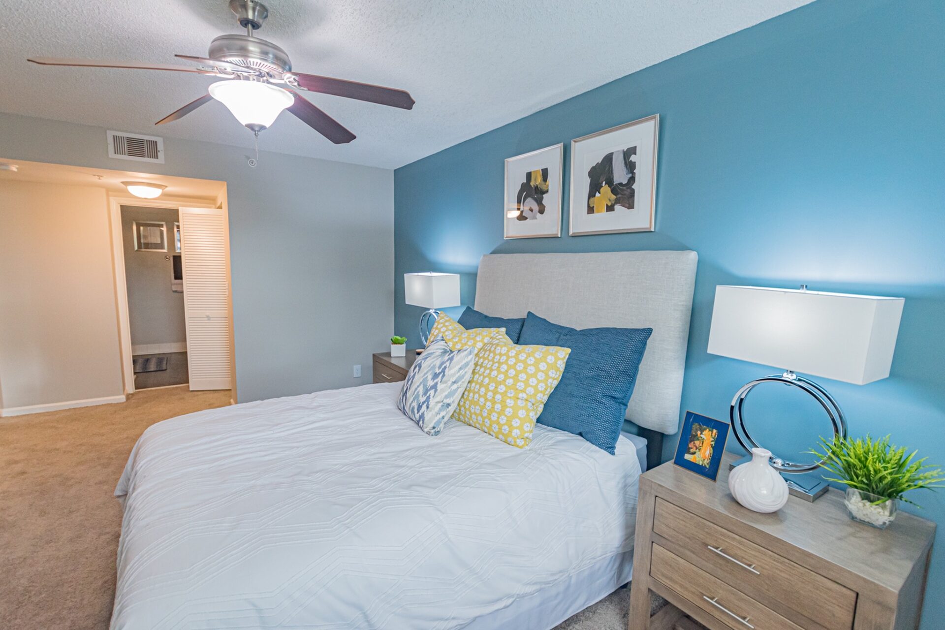 Carpeted bedroom with a ceiling fan that is connected to a bathroom.