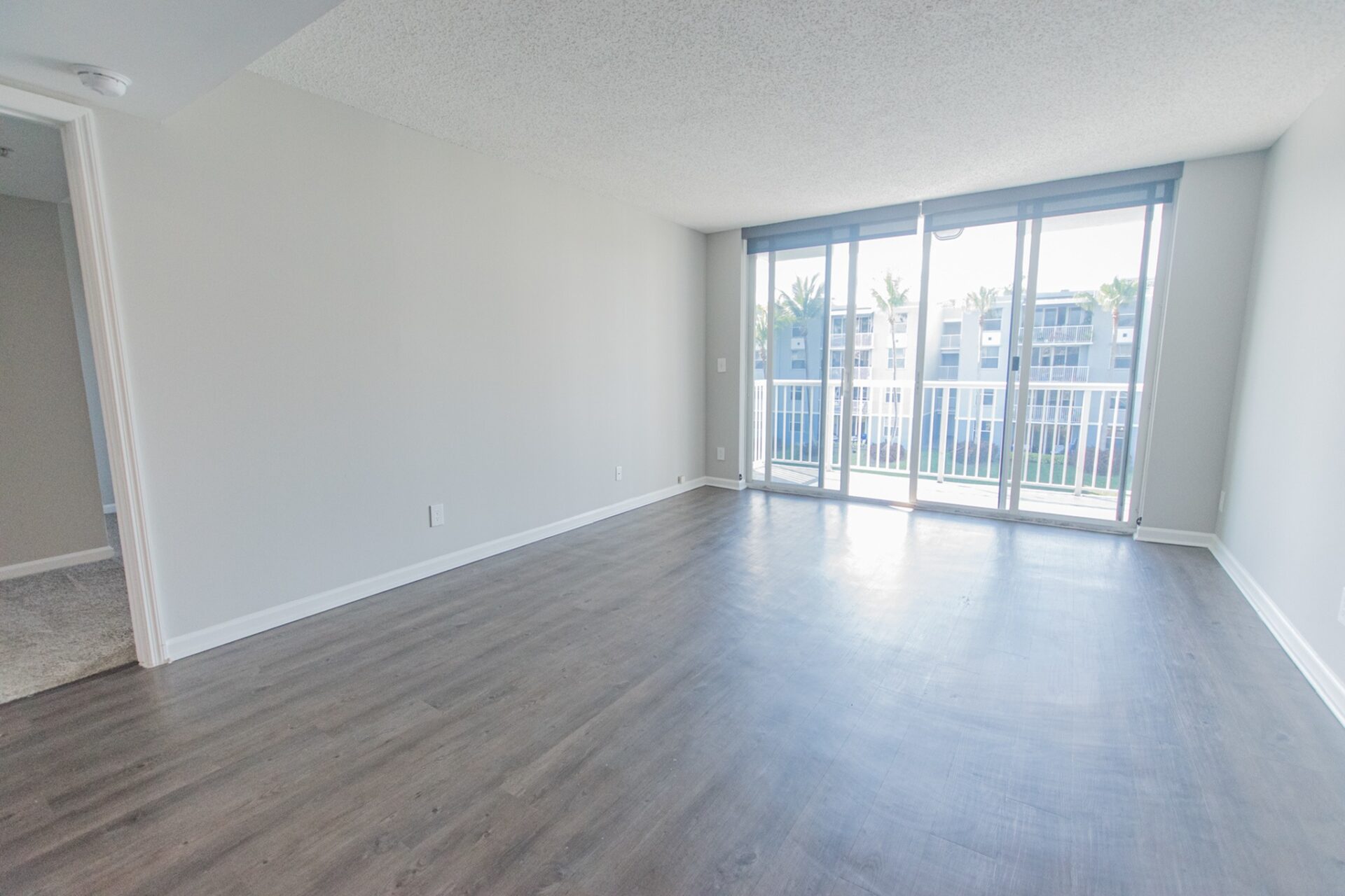 Spacious living space with sliding window doors leading to the balcony.