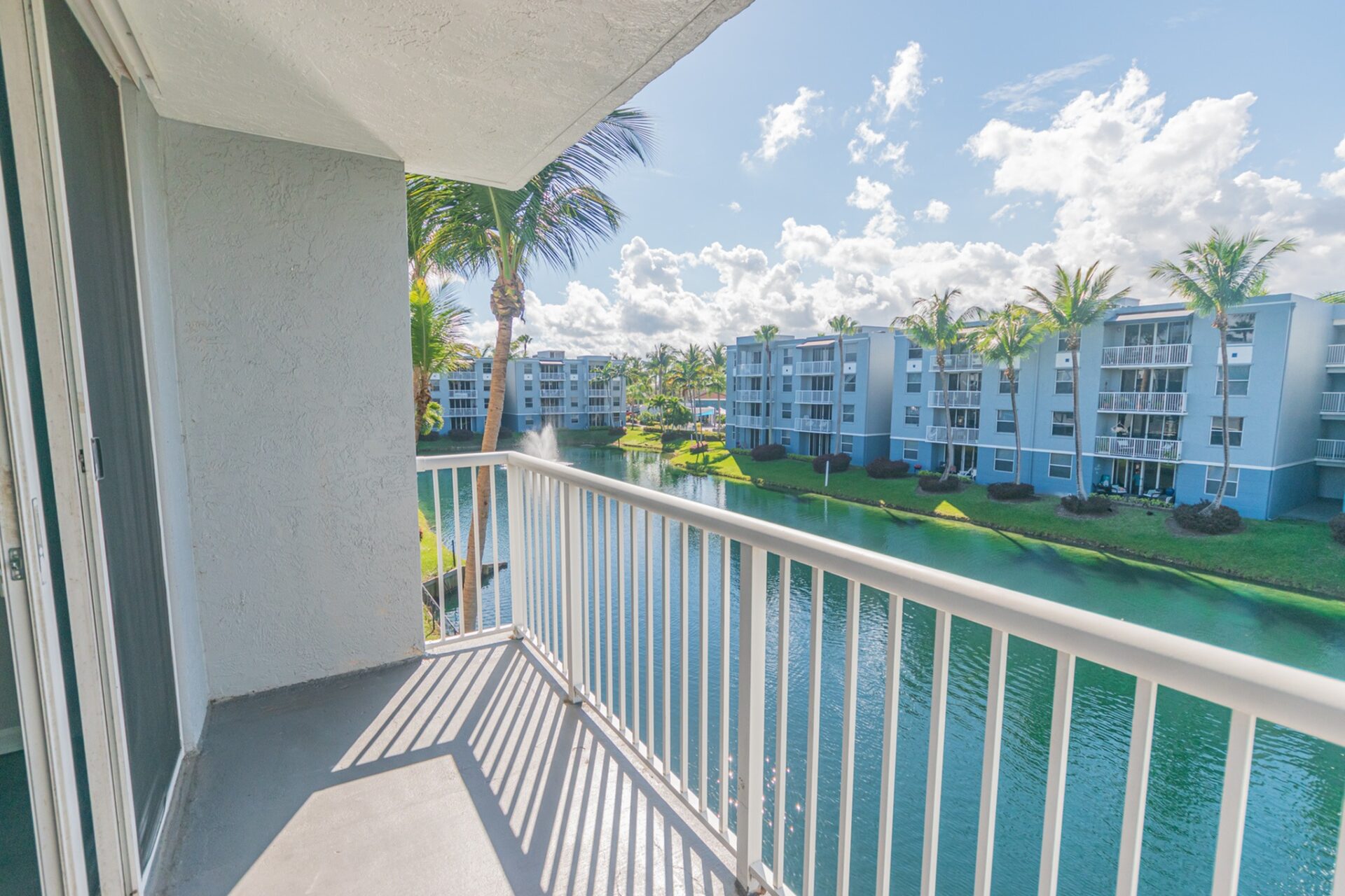 Balcony view of Beachwalk at Sheridan apartments with a lake in the middle.