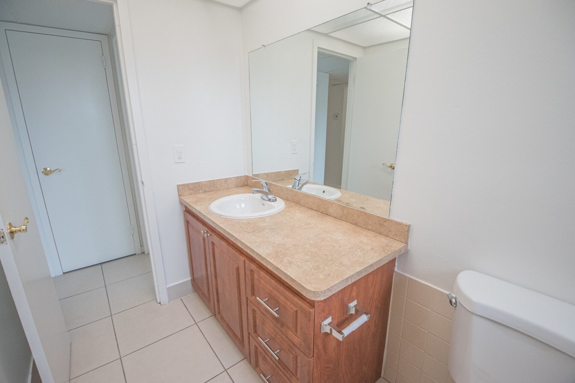 Bathroom with a mirror, sink, and wooden cabinets.