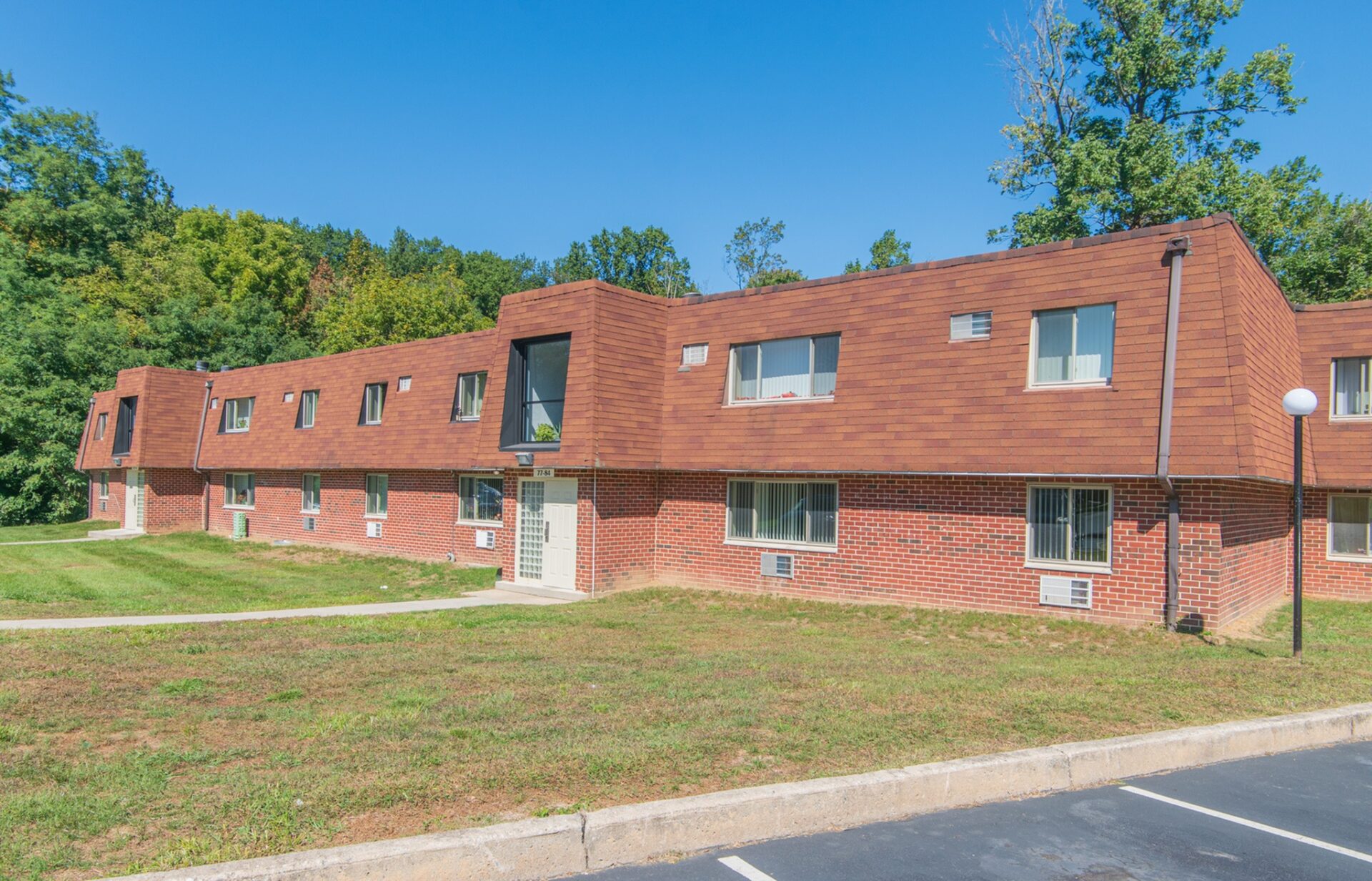 Exterior of Hollow Run Apartments with parking spaces.