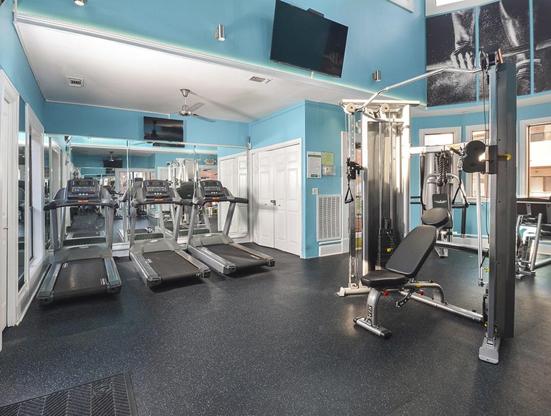 The fitness center with many exercise machines at Waterloo Place Apartments