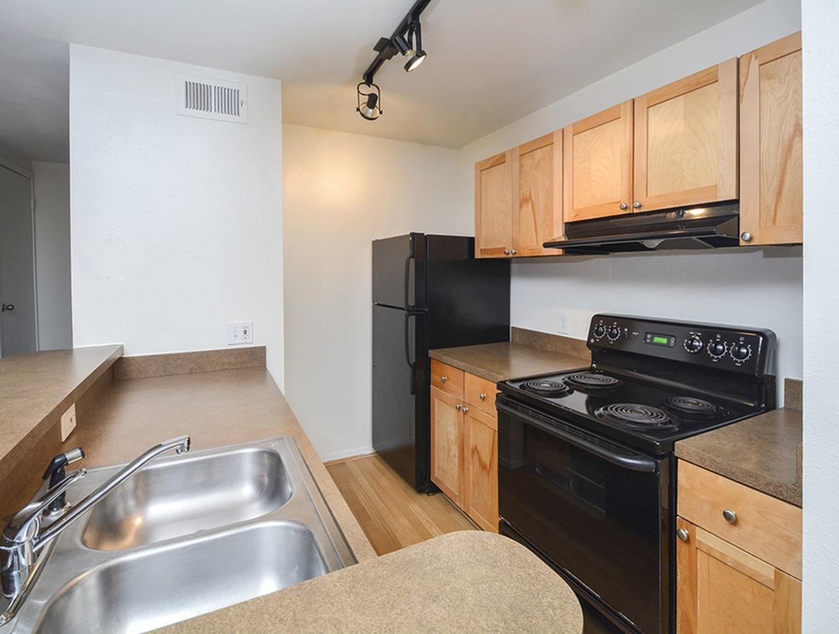Waterloo Place Apartments with wood cabinets and black appliances