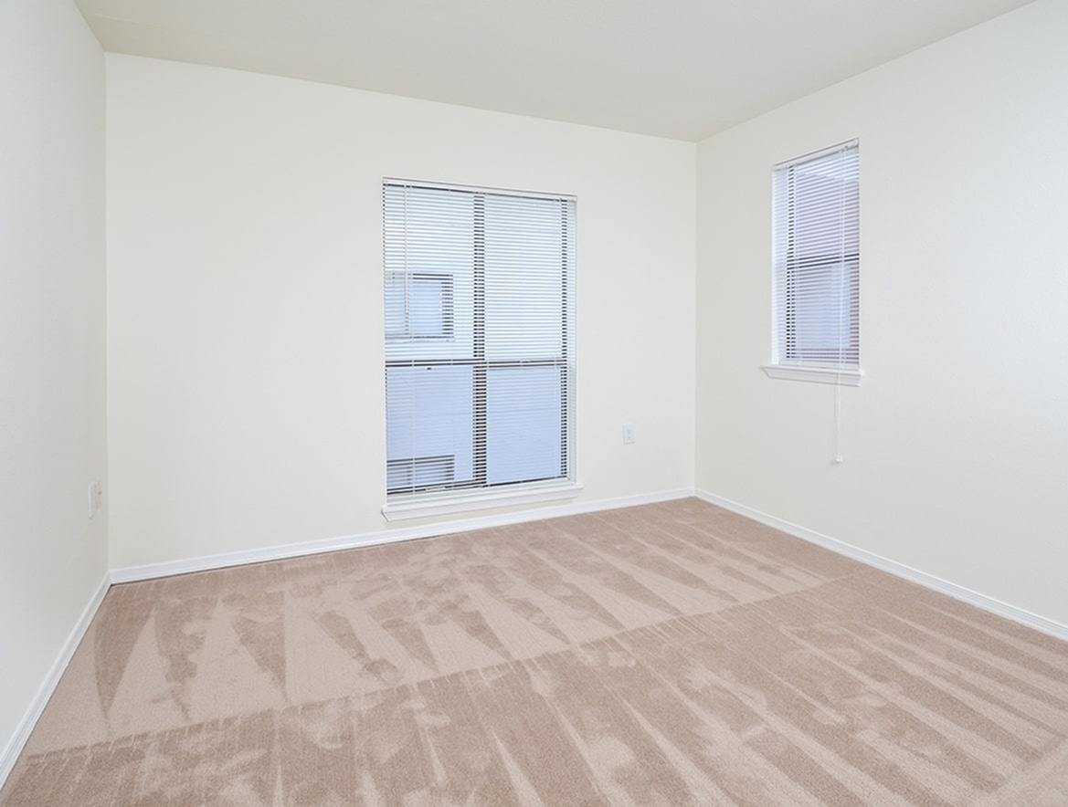 Waterloo Place Apartments carpeted bedroom with a large window