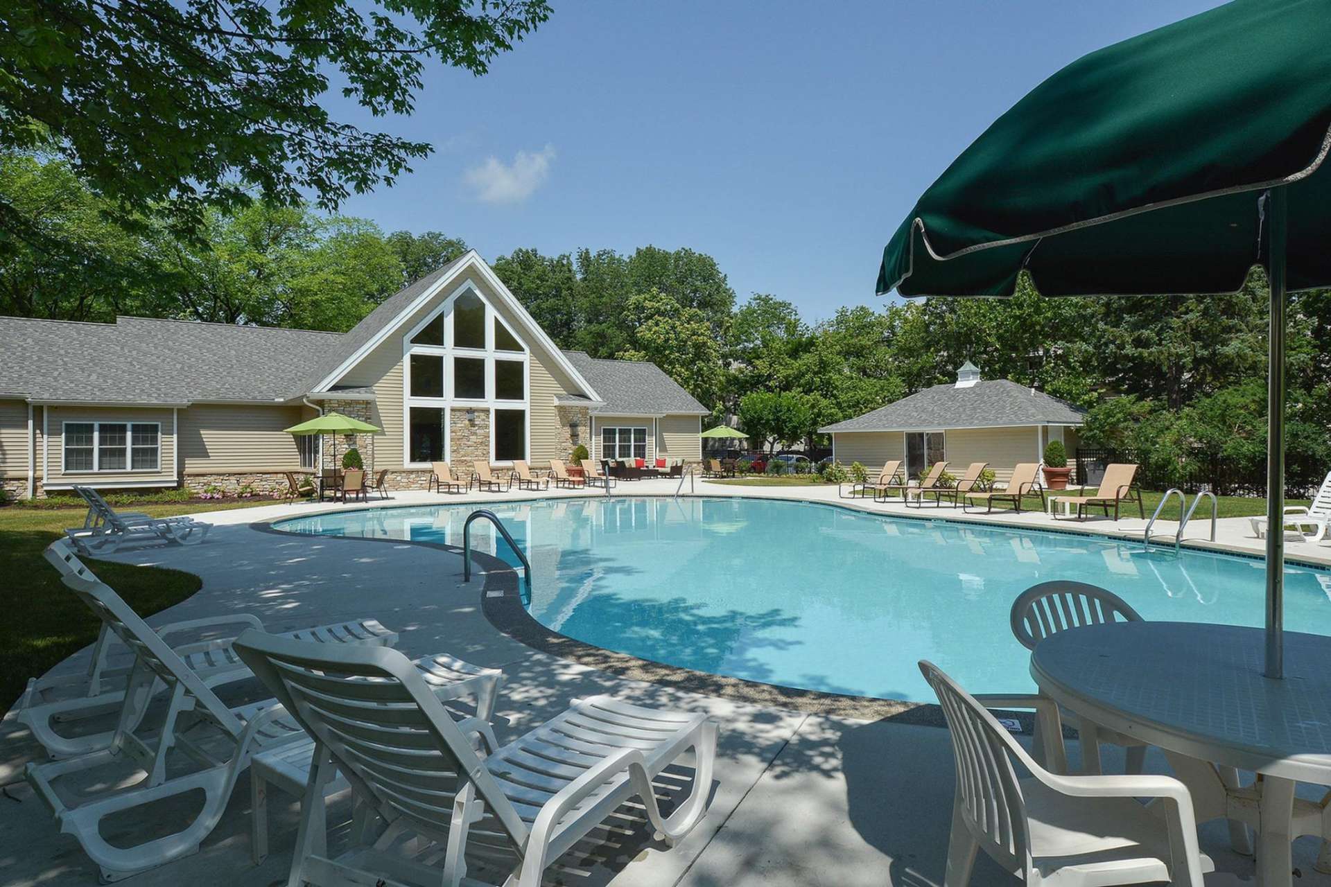 Large clubhouse with a dazzling pool surrounded by lounge chairs at The Lafyette