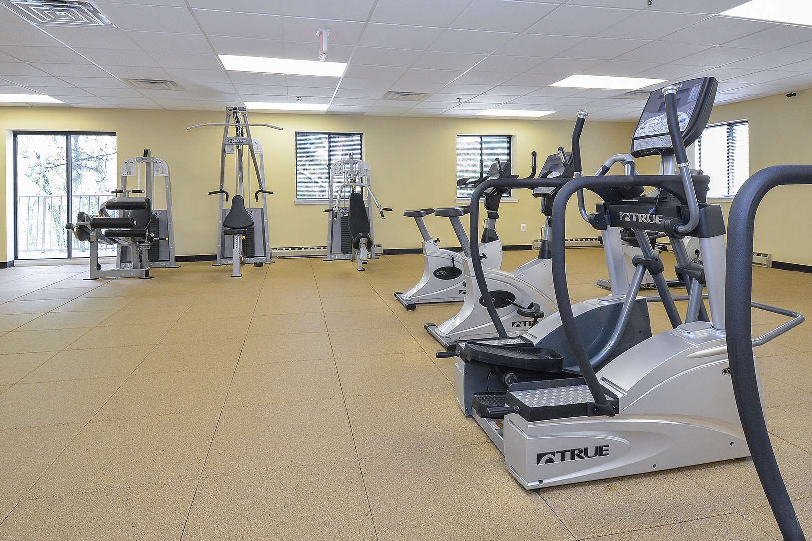 The large fitness center with windows and a balcony at Valley Forge Suites