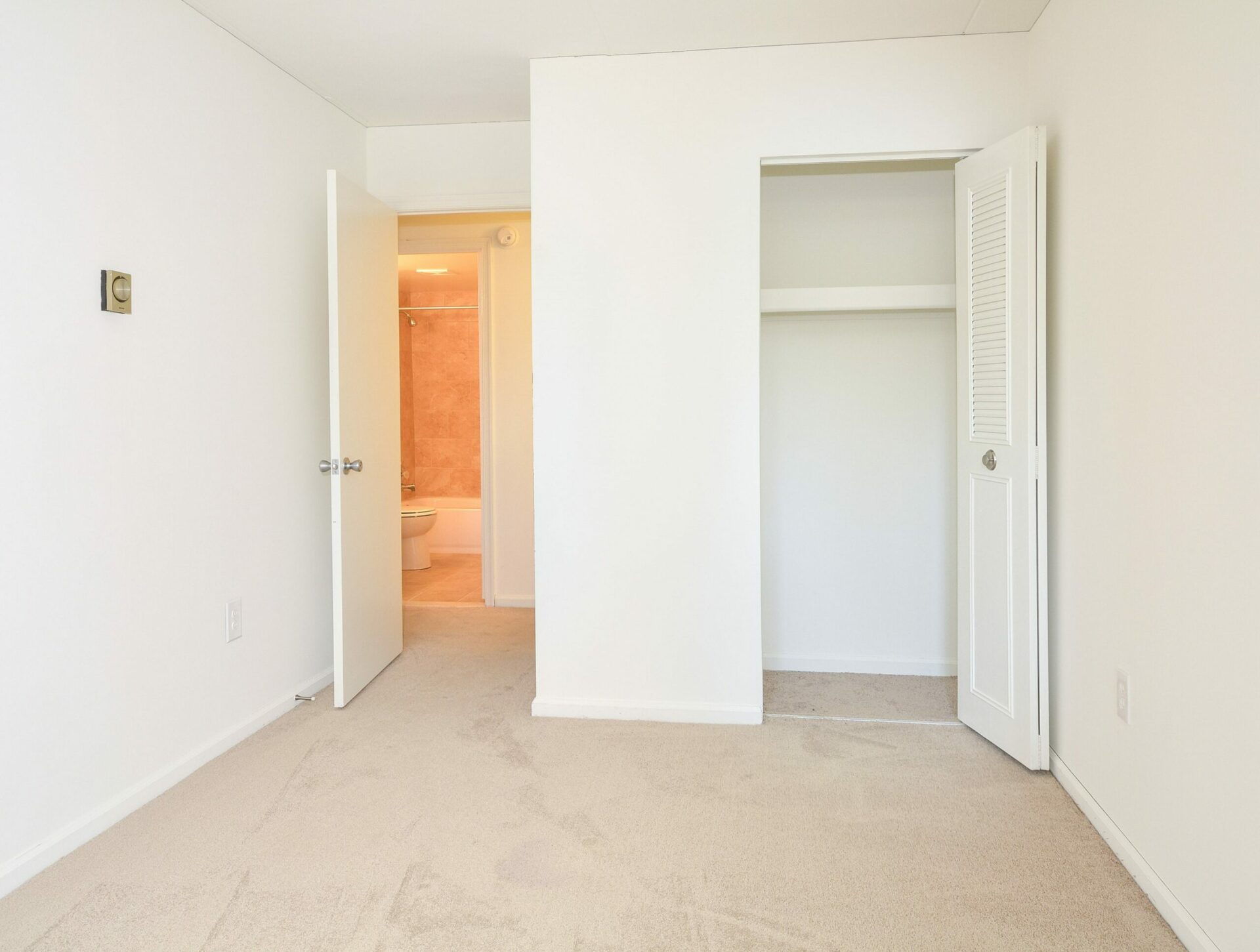 A bedroom with a closet and a door leading to the hallway bathroom at Valley Forge Suites