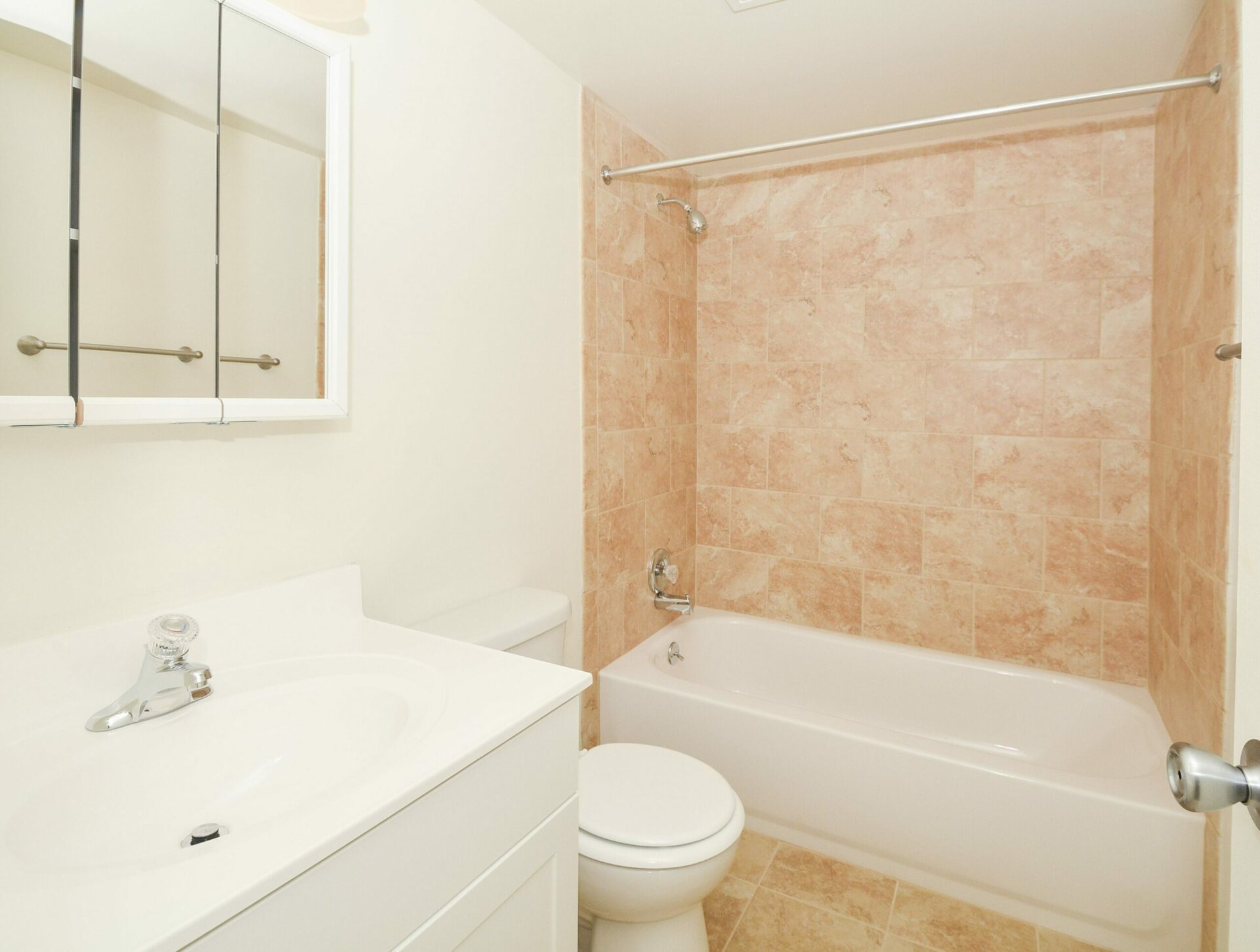 A tiled bathroom with a large tub and shower at Valley Forge Suites