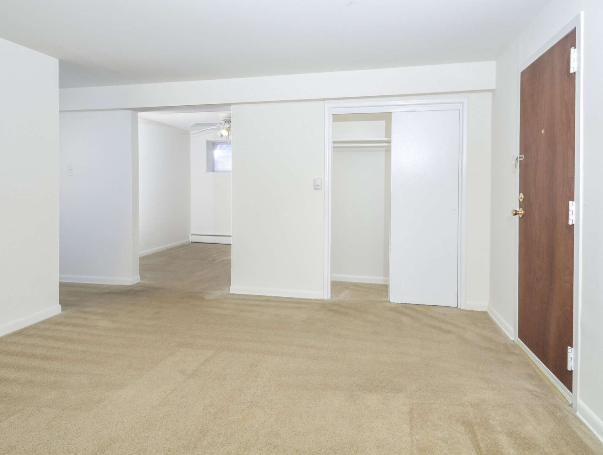 Living room space with beige carpets and sliding closet doors.