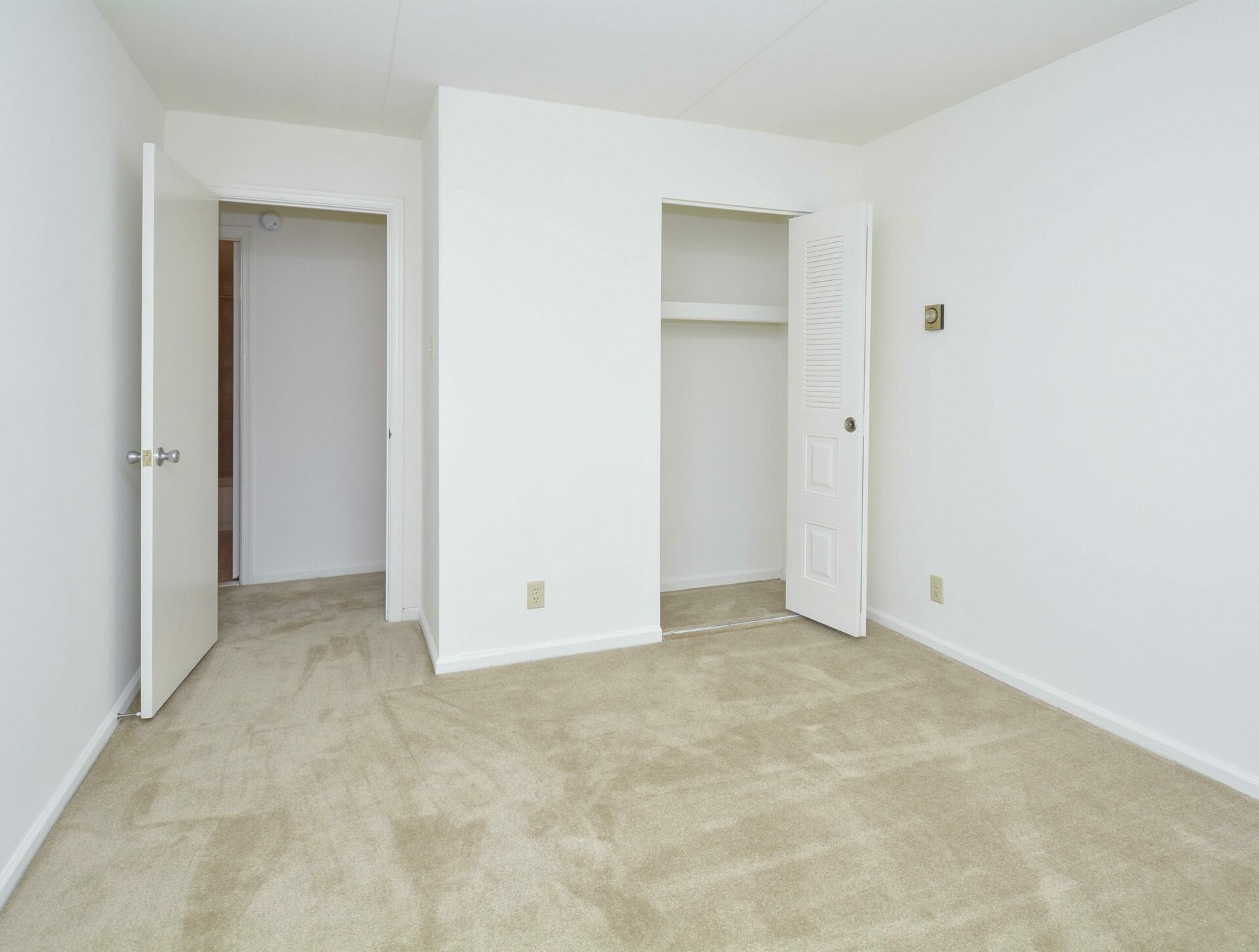 A carpeted bedroom with a closet at Valley Forge Suites