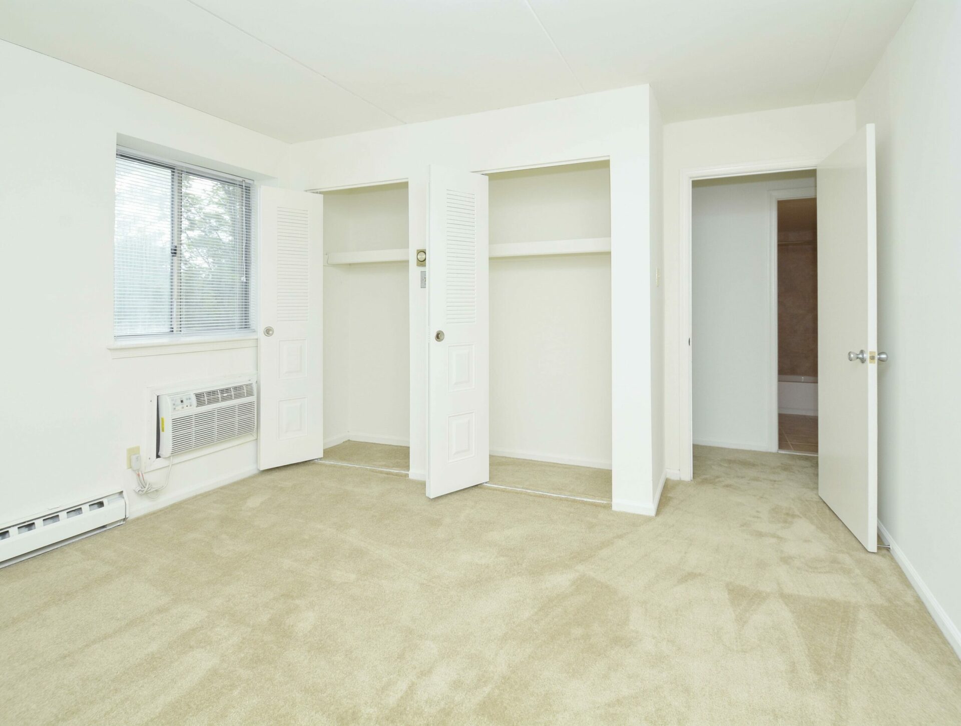 Carpeting, a window and two closets in a bedroom at Valley Forge Suites