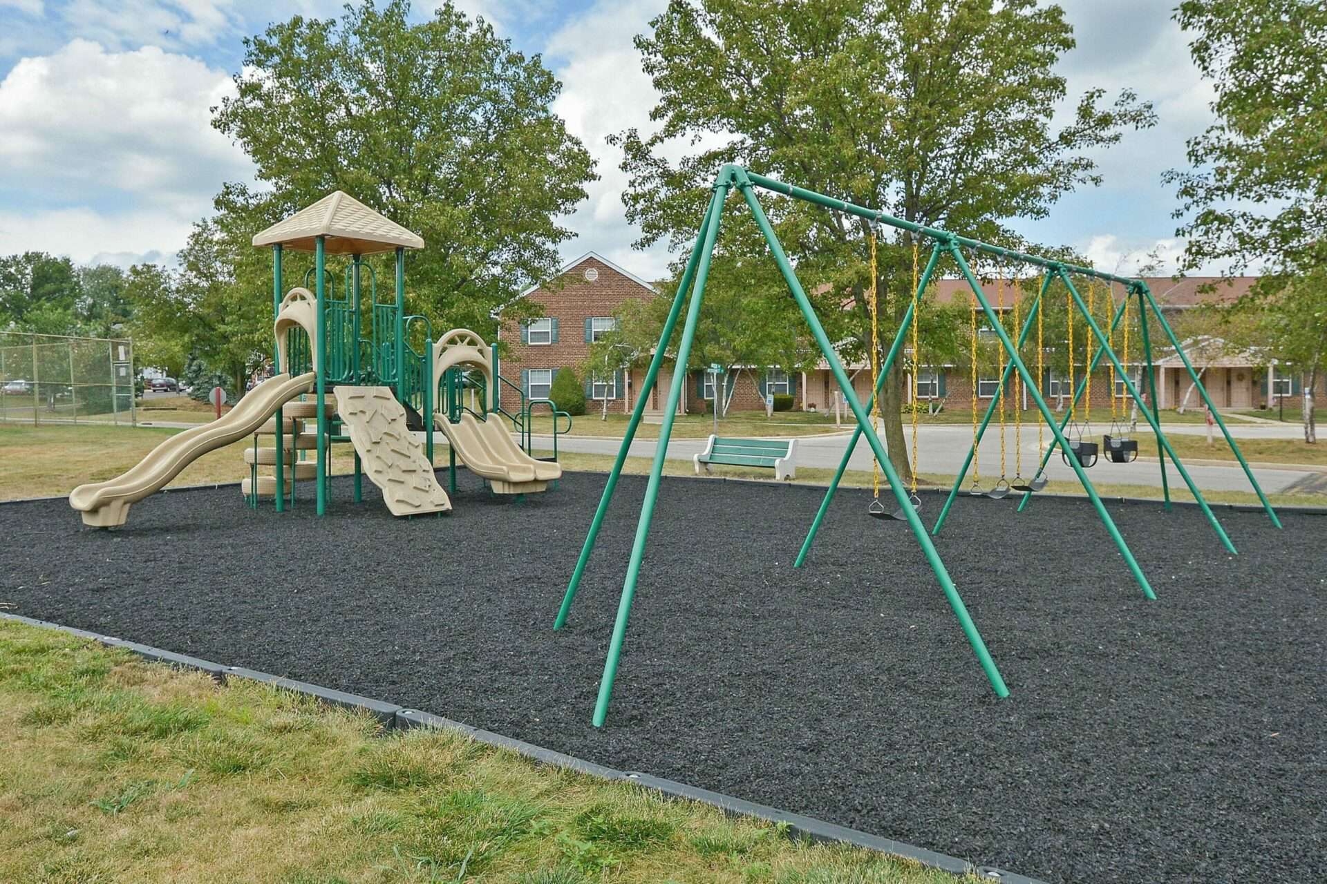 Kids playground surrounded by trees and grass at Westover Village