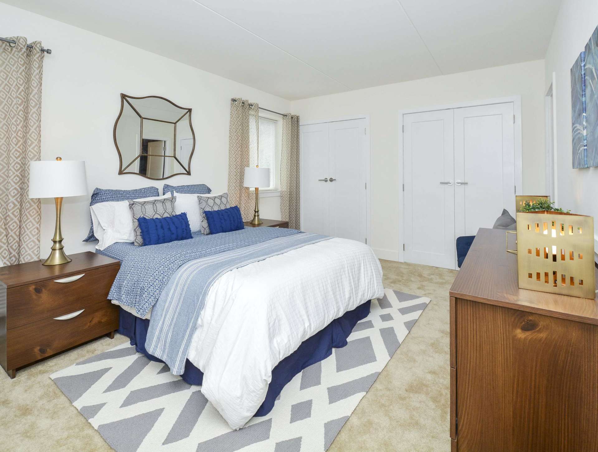 Spacious and carpeted bedroom with closet space and 2 windows.