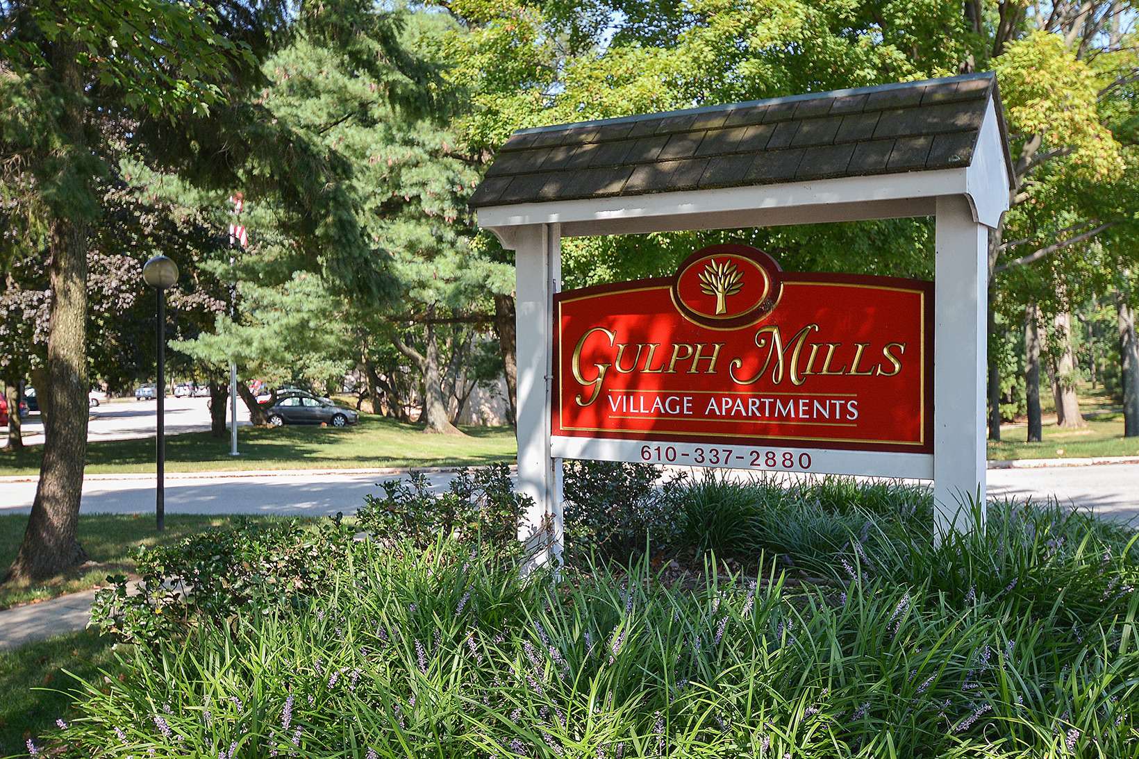 Gulph Mills Village Apartments sign on grass with trees surrounding the sign in King of Prussia, PA.