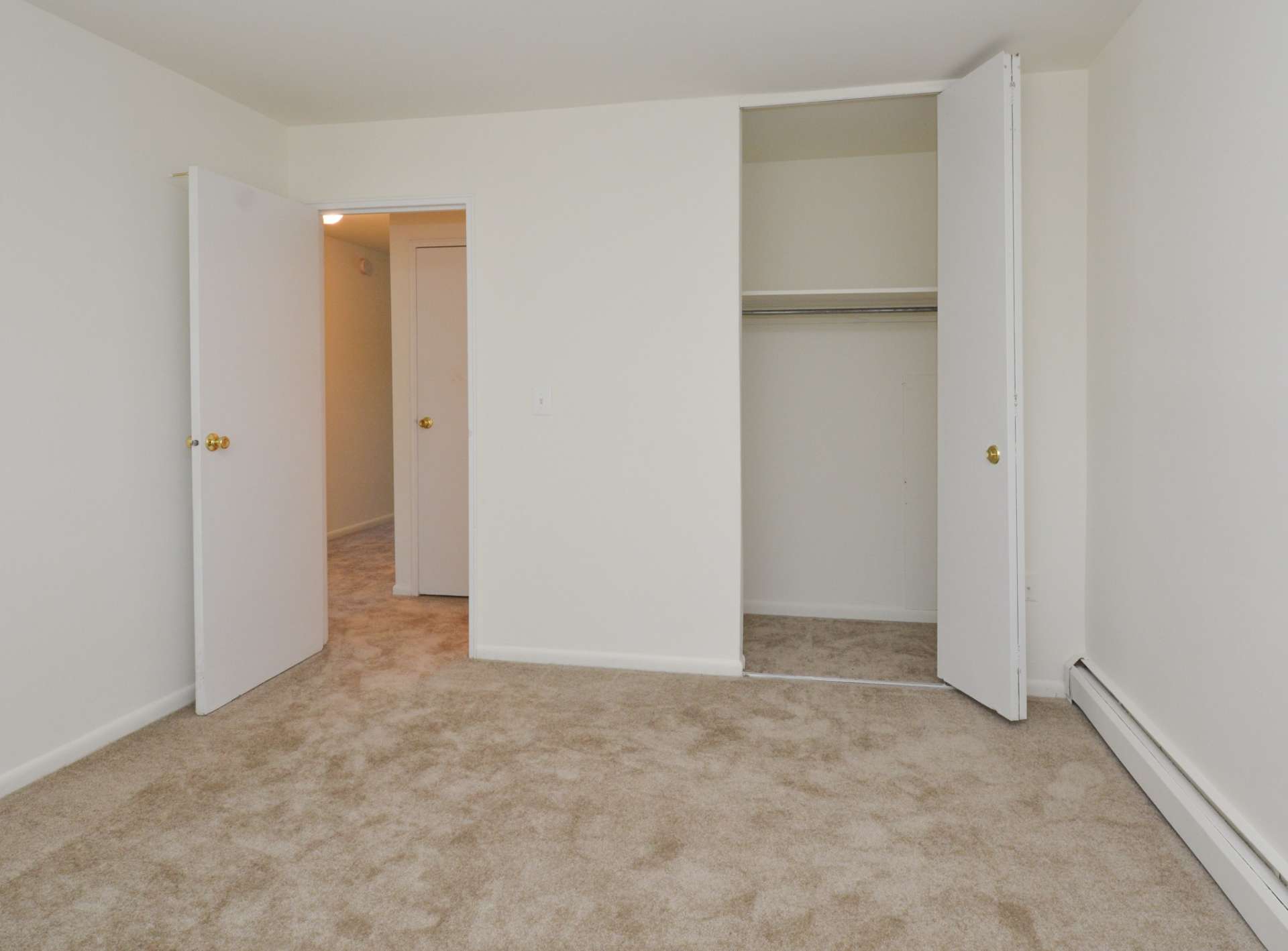 Bedroom with beige carpets and a closet in an apartment in Dover, DE.