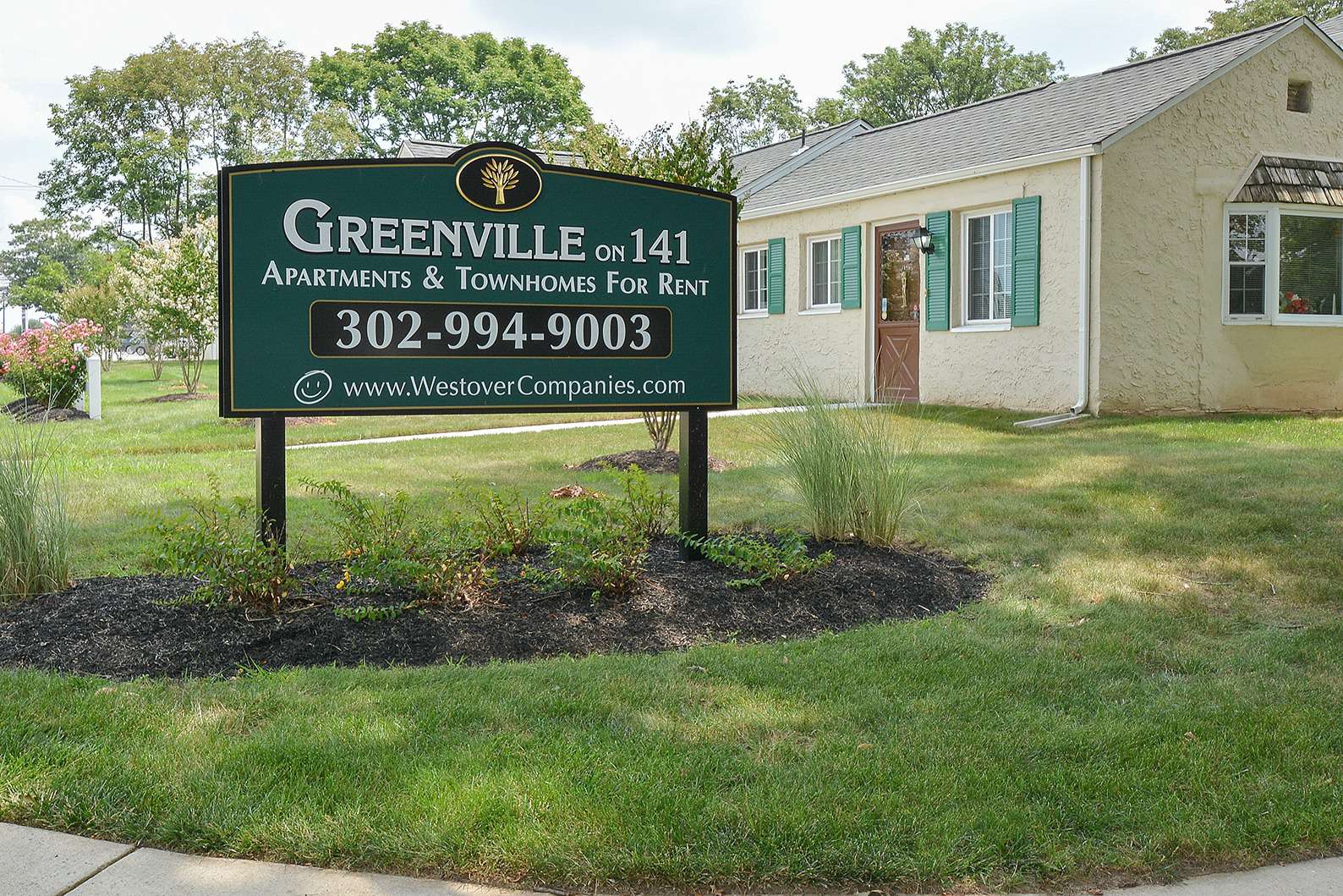 Greenville on 141 Apartments and Townhomes sign on landscaped grass.