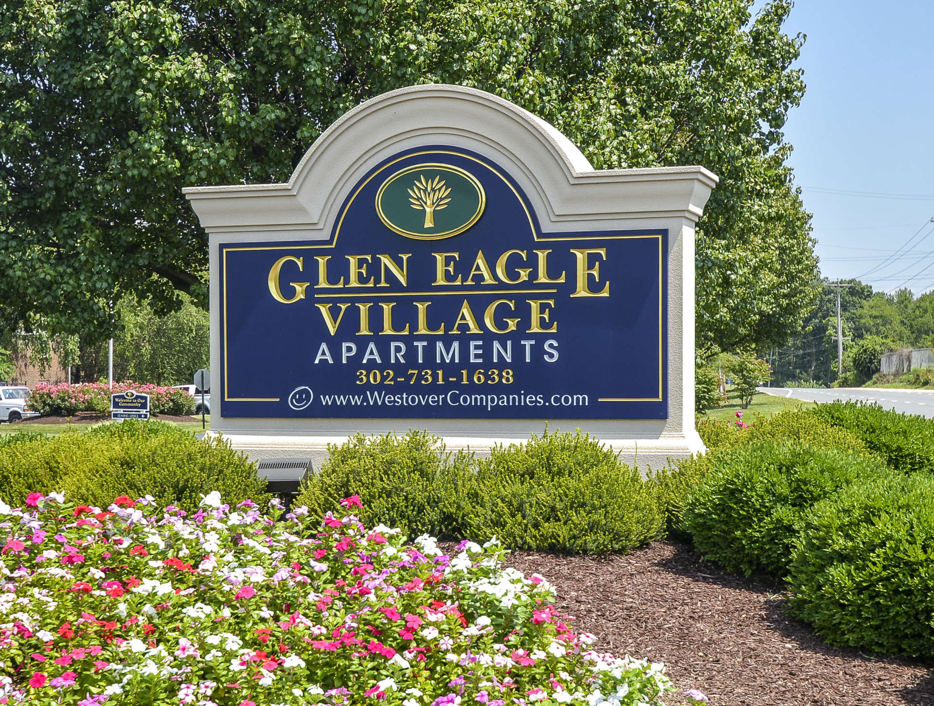 Glen Eagle Village apartments sign in Newark, DE with shrubs around the sign.