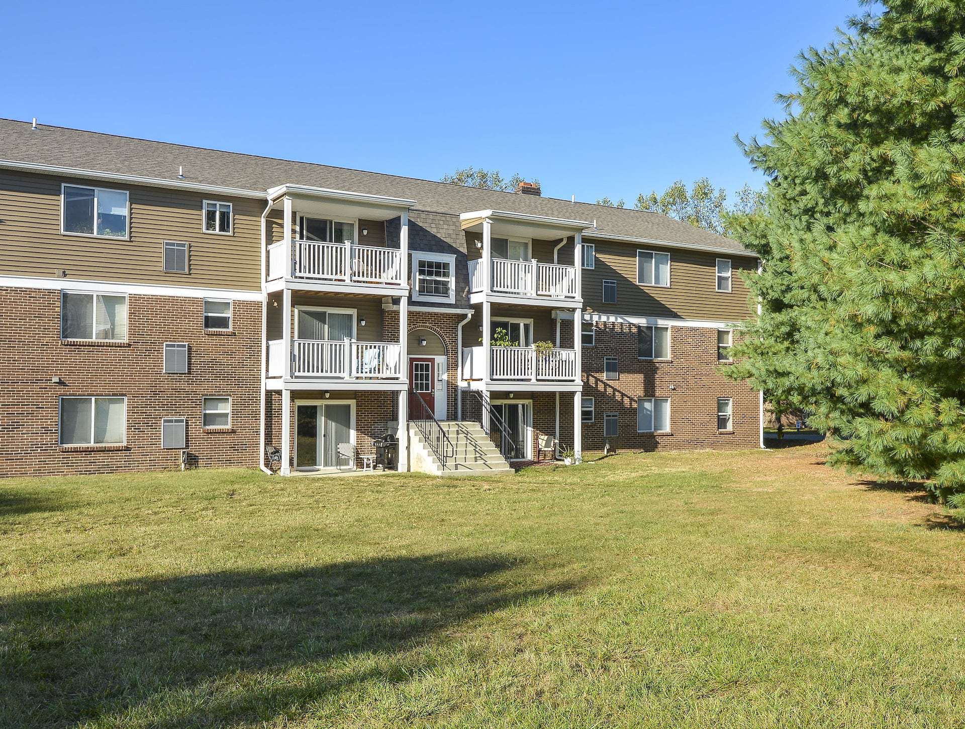 Exterior of an apartment building , fitted with a lawn, and steps