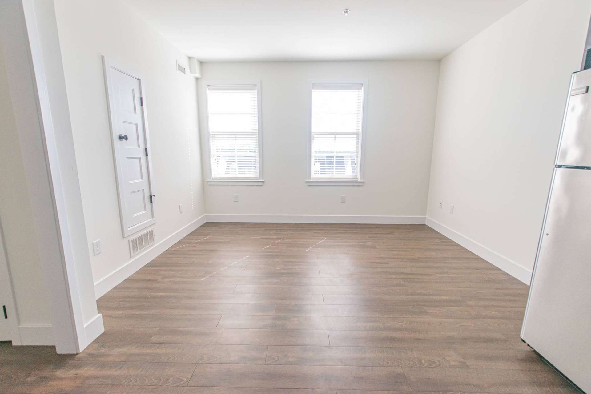 Spacious dining area with hardwood-style flooring and 2 windows.