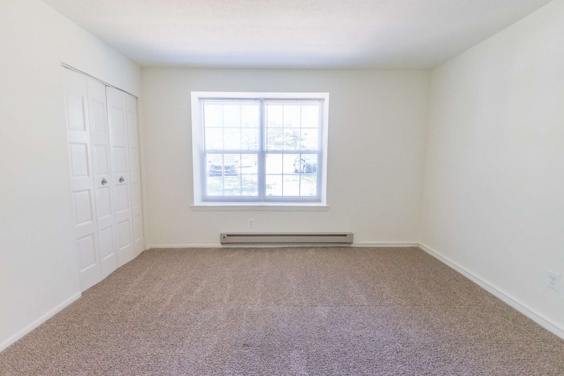 Willow Run Apartments carpeted bedroom with large window and heating
