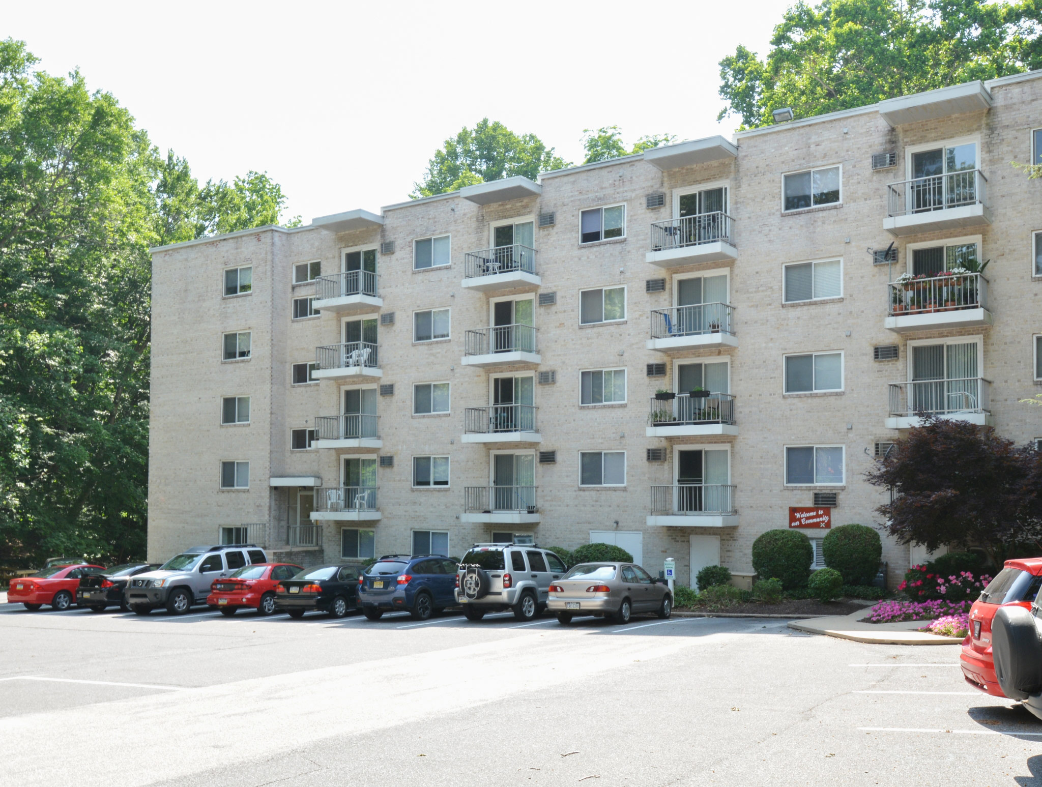 Exterior of an apartment building at Gayley Park, fitted with concrete flooring, paved walkway, and railing