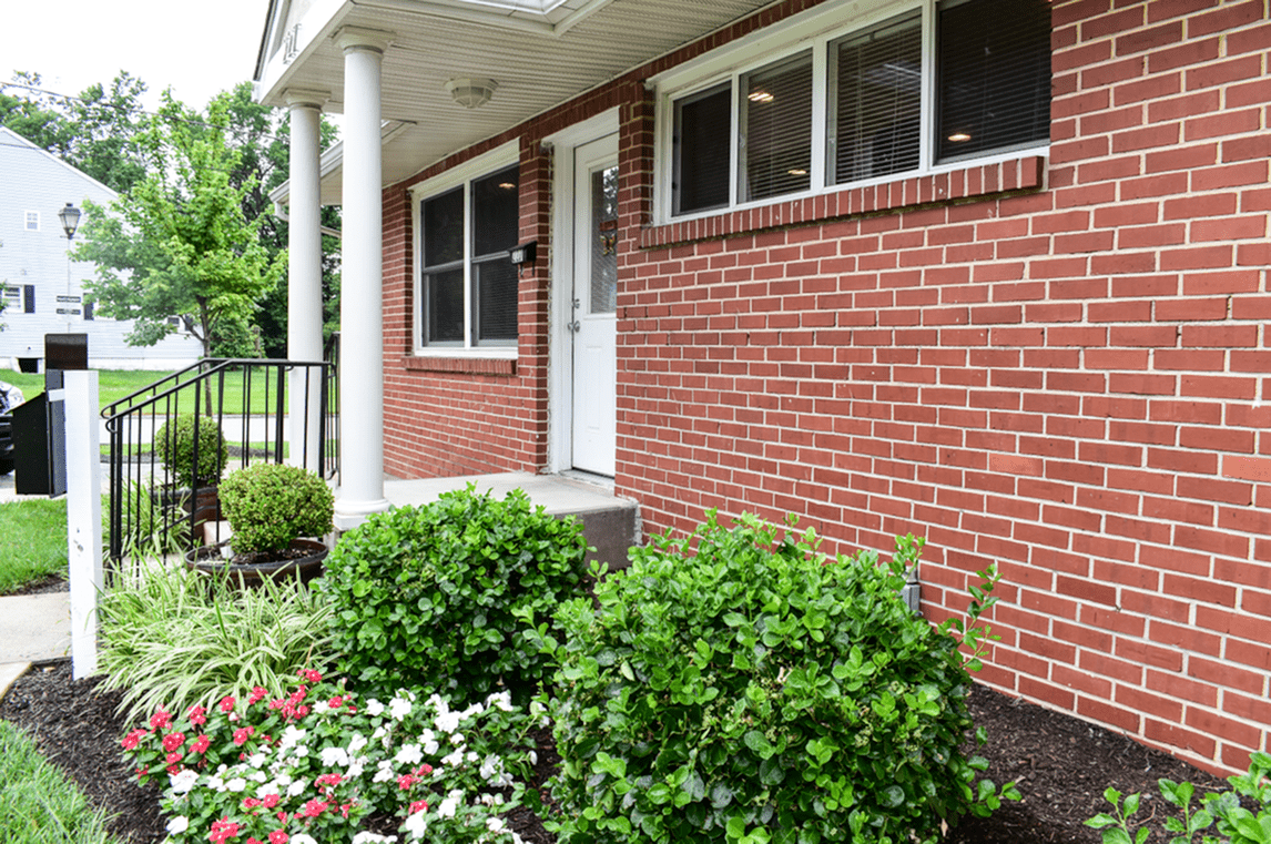 Leasing office entrance area, fitted with steps, and a garden