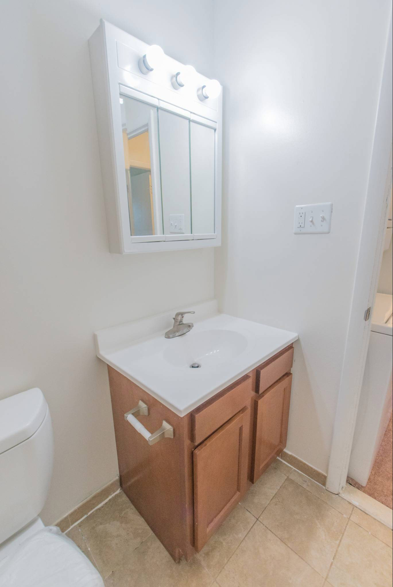 Bathroom with a sink, mirror, and toilet.