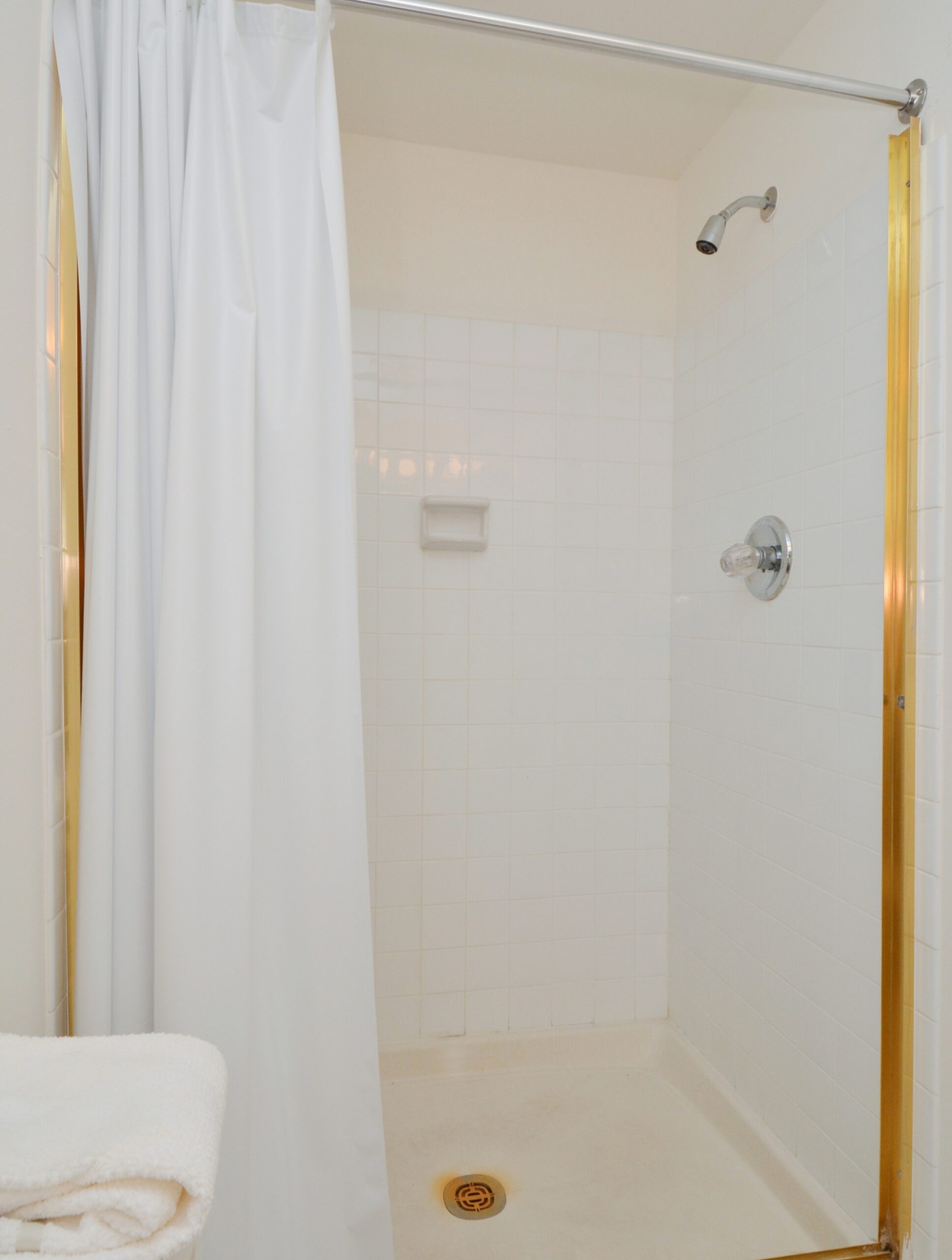 A shower with white tile at Valley Stream Apartments