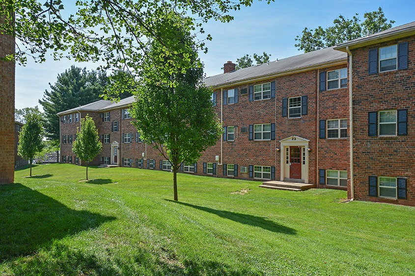 Landscaped yards and several trees in front of Naamans Village apartment buildings.