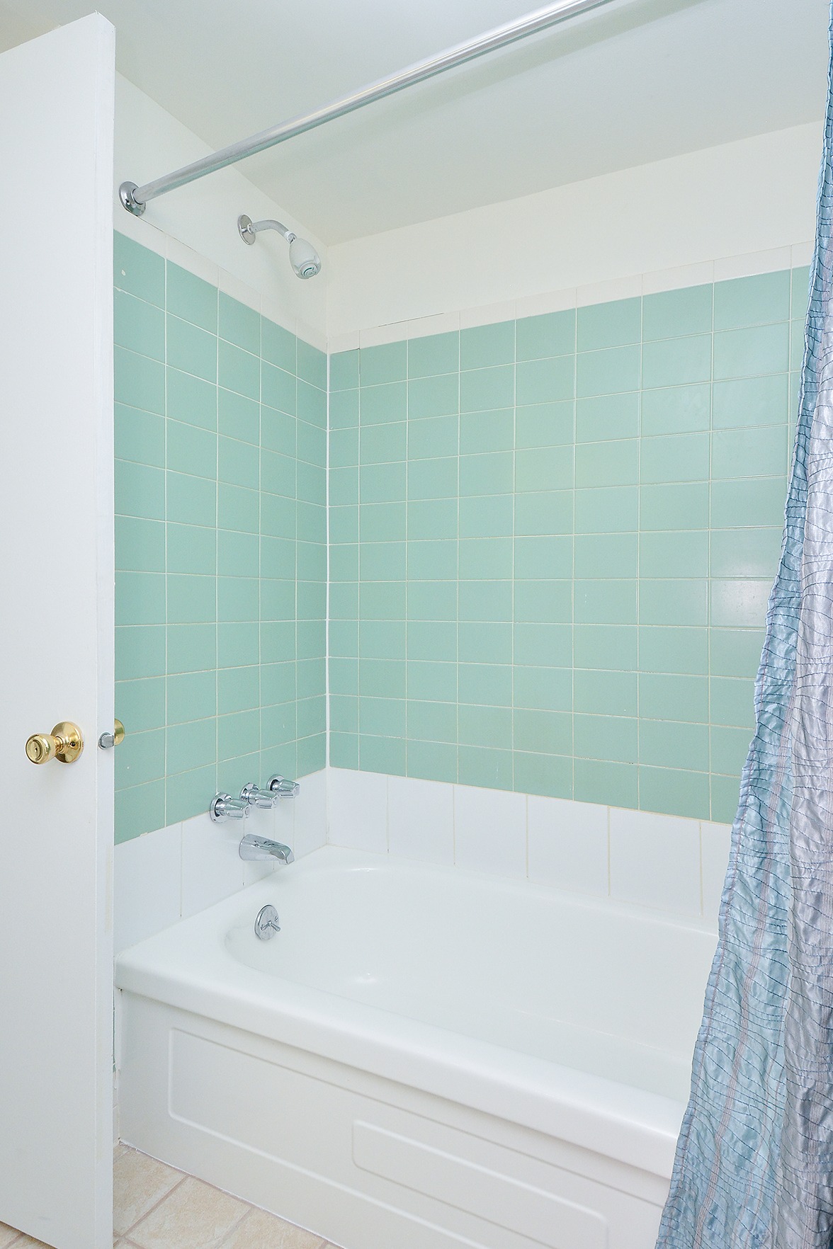Bathtub with mint tiles.
