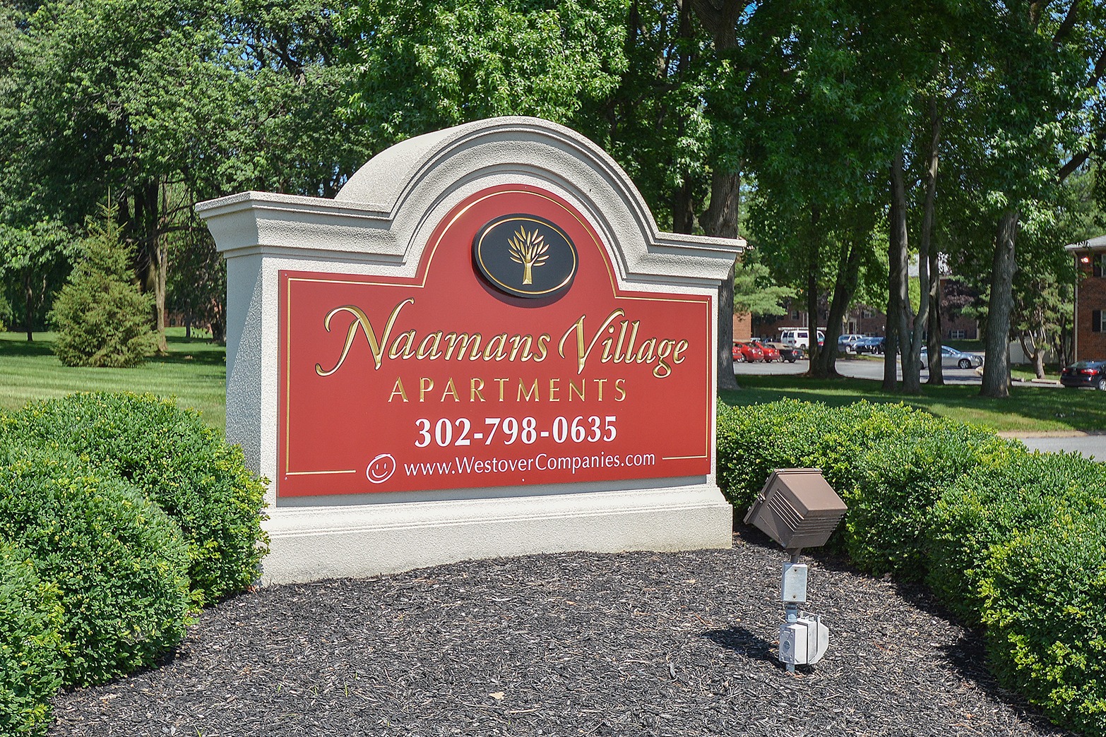 Naamans Village Apartments sign with mulch and shrubs around the sign.