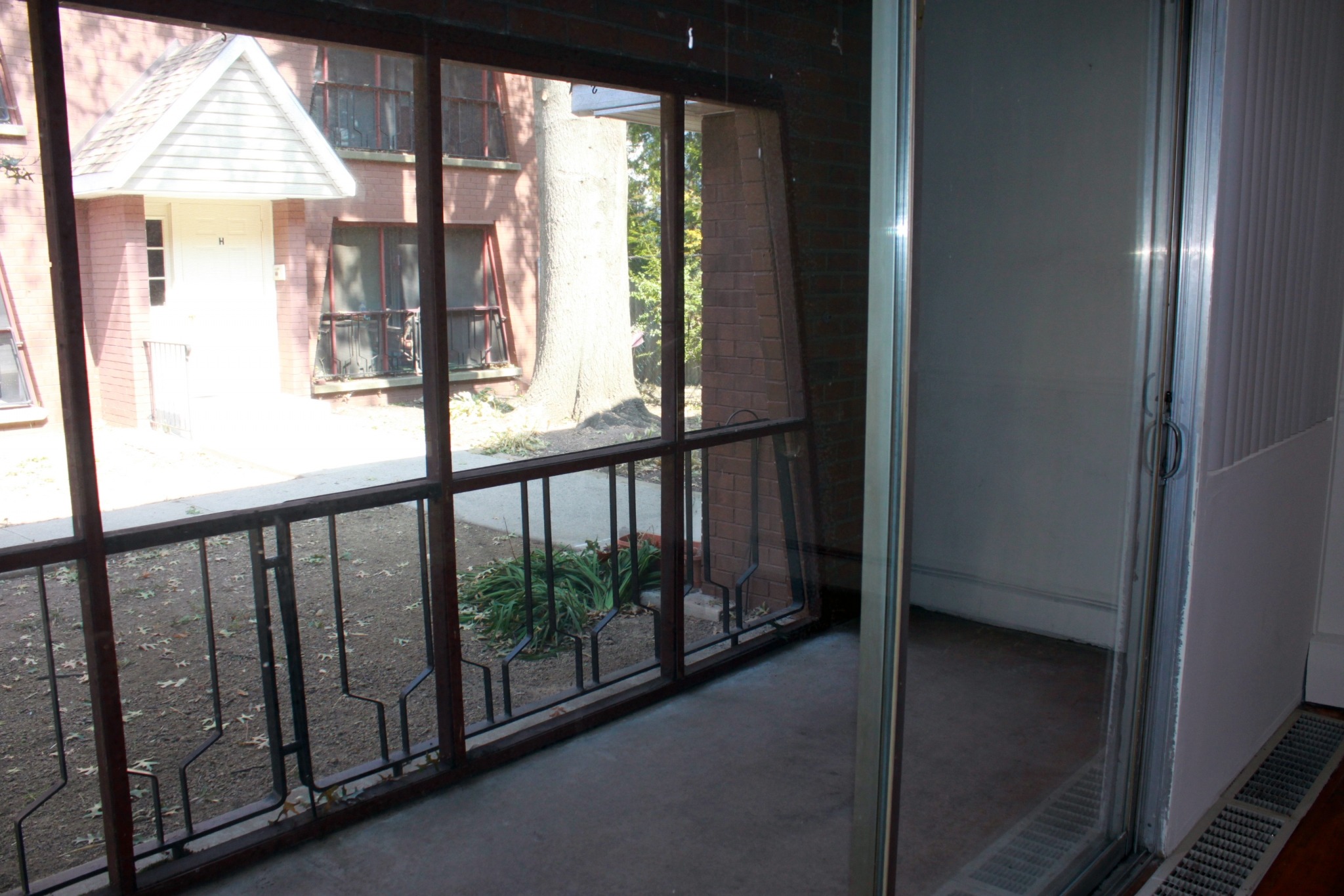 Sliding glass doors that lead to the patio with a view of the apartment buildings.