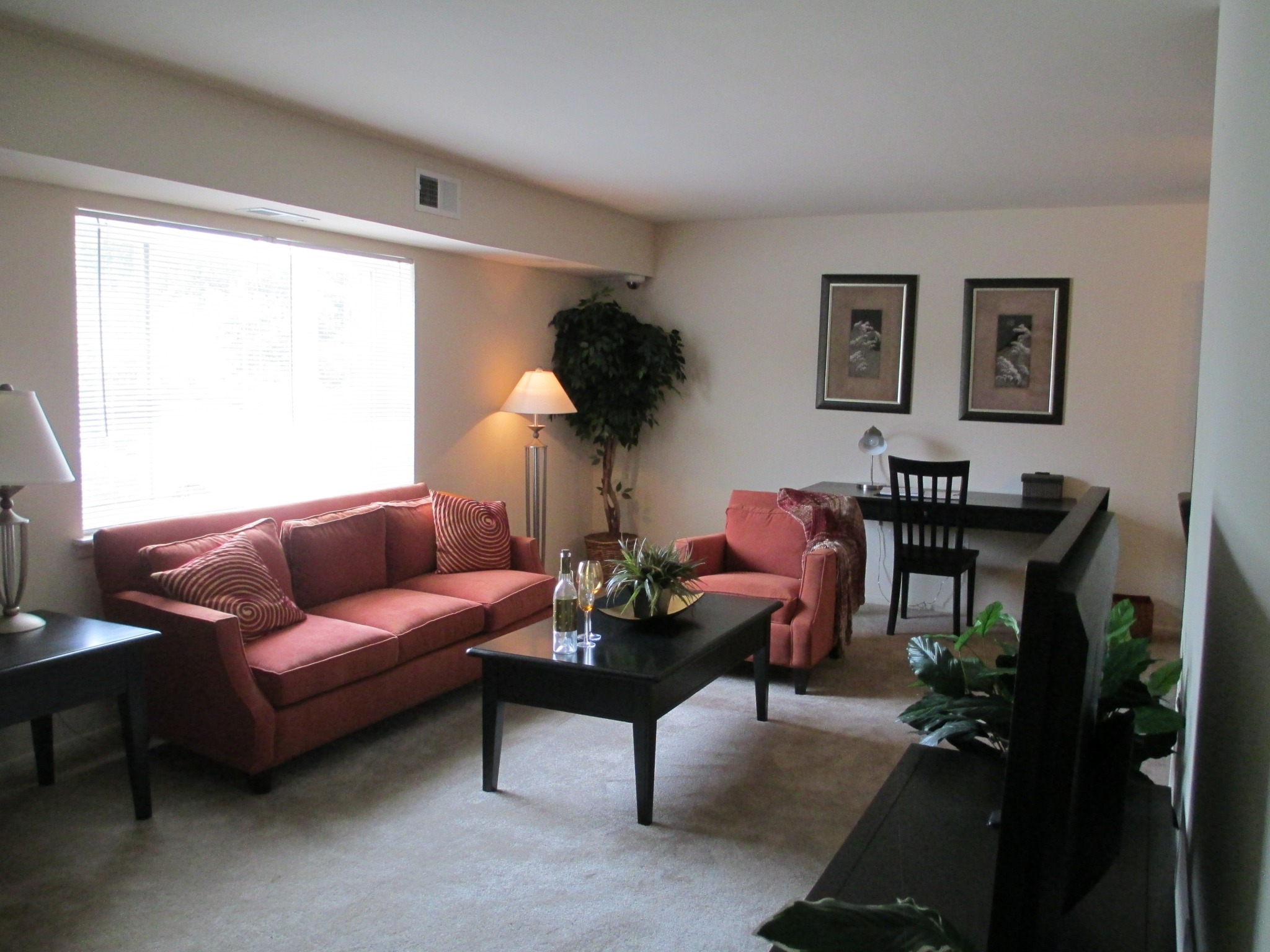 The clubhouse area of our community, fitted with carpet flooring, couches, and a high ceiling