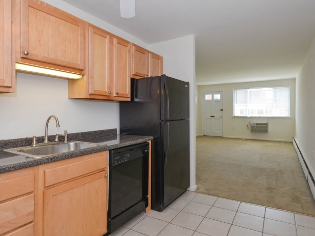 Kitchen area of an apartment, fitted with tiled flooring, stainless steel appliances, and spacious cabinets