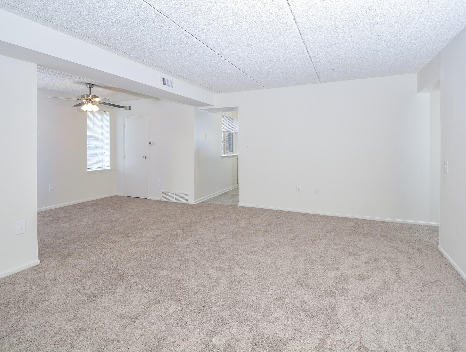 The bedroom area of an apartment unfurnished, fitted with carpet flooring, and a private bathroom