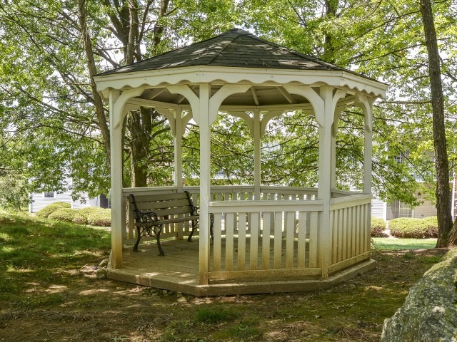 Victoria Crossing pergola with a bench under trees