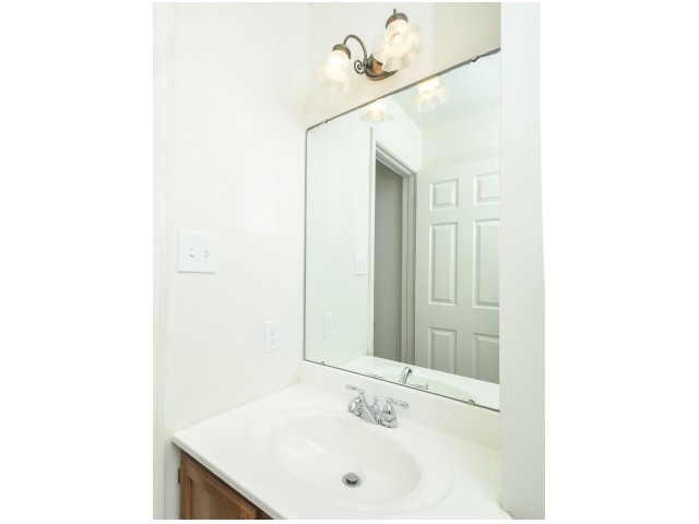 Victoria Crossing Apartments bathroom vanity with lighting and a mirror