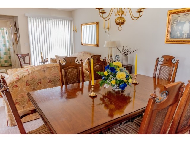 A 6-seater dining table and two couches in an apartment at the Upper Deerfield Estates