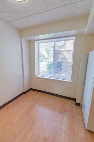Living room area of an apartment unfurnished, fitted with carpet flooring, an entrance door, and a huge window