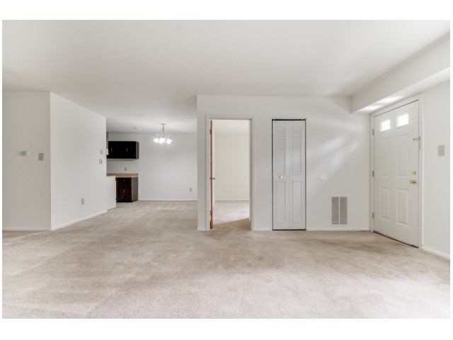 Spacious living area with light beige carpets at Indian Run Apartments.
