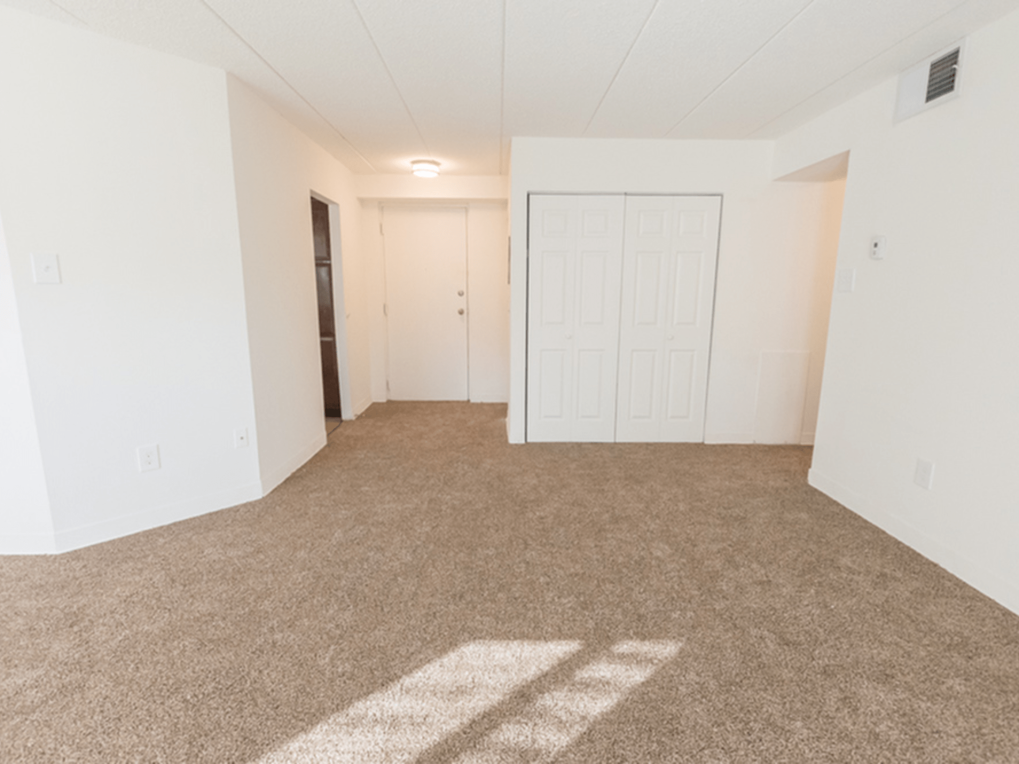 Carpeted living room at Winslow House Apartments