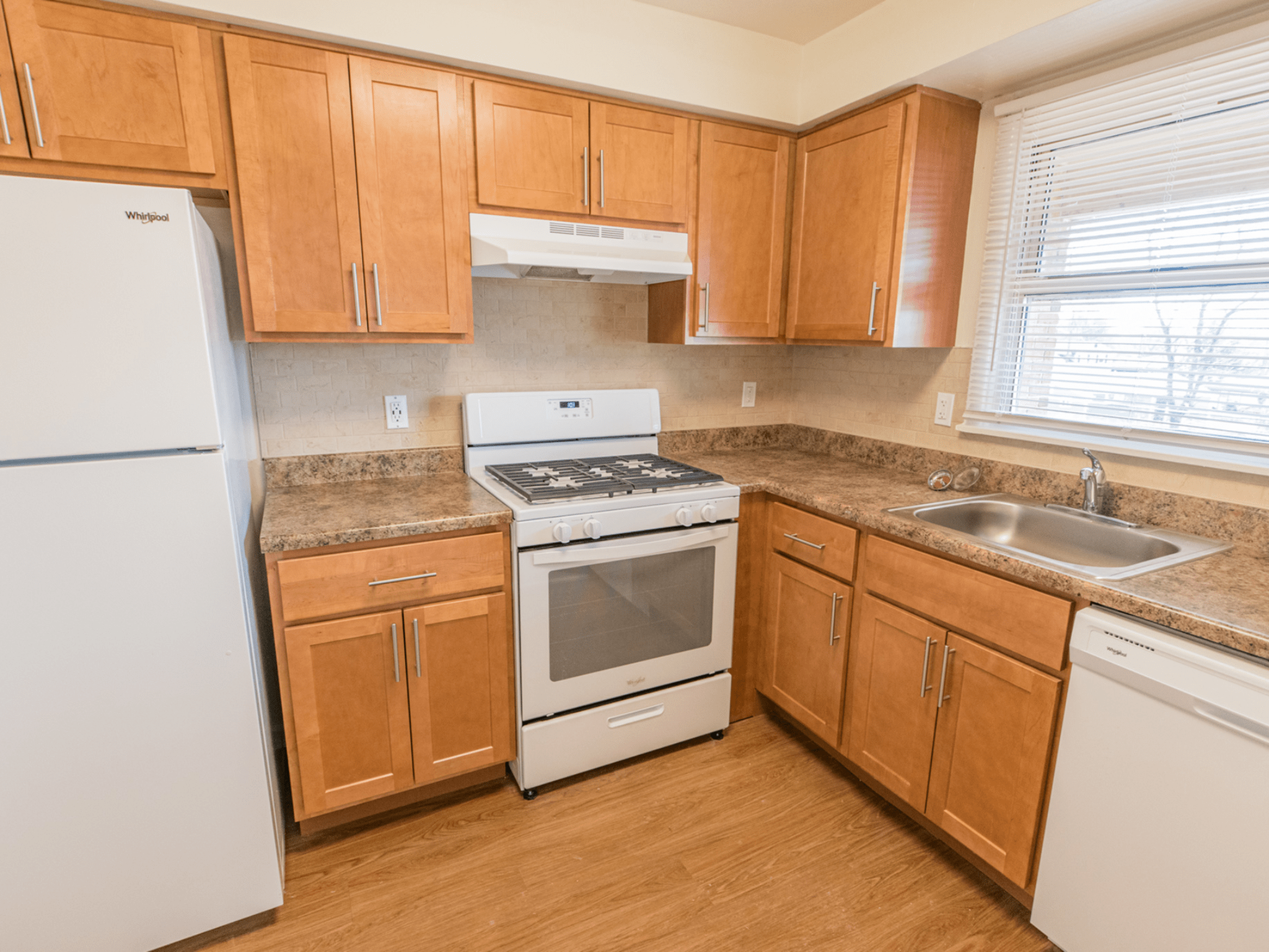 Polo Ridge Apartments kitchen with brown cabinets and whitle appliances
