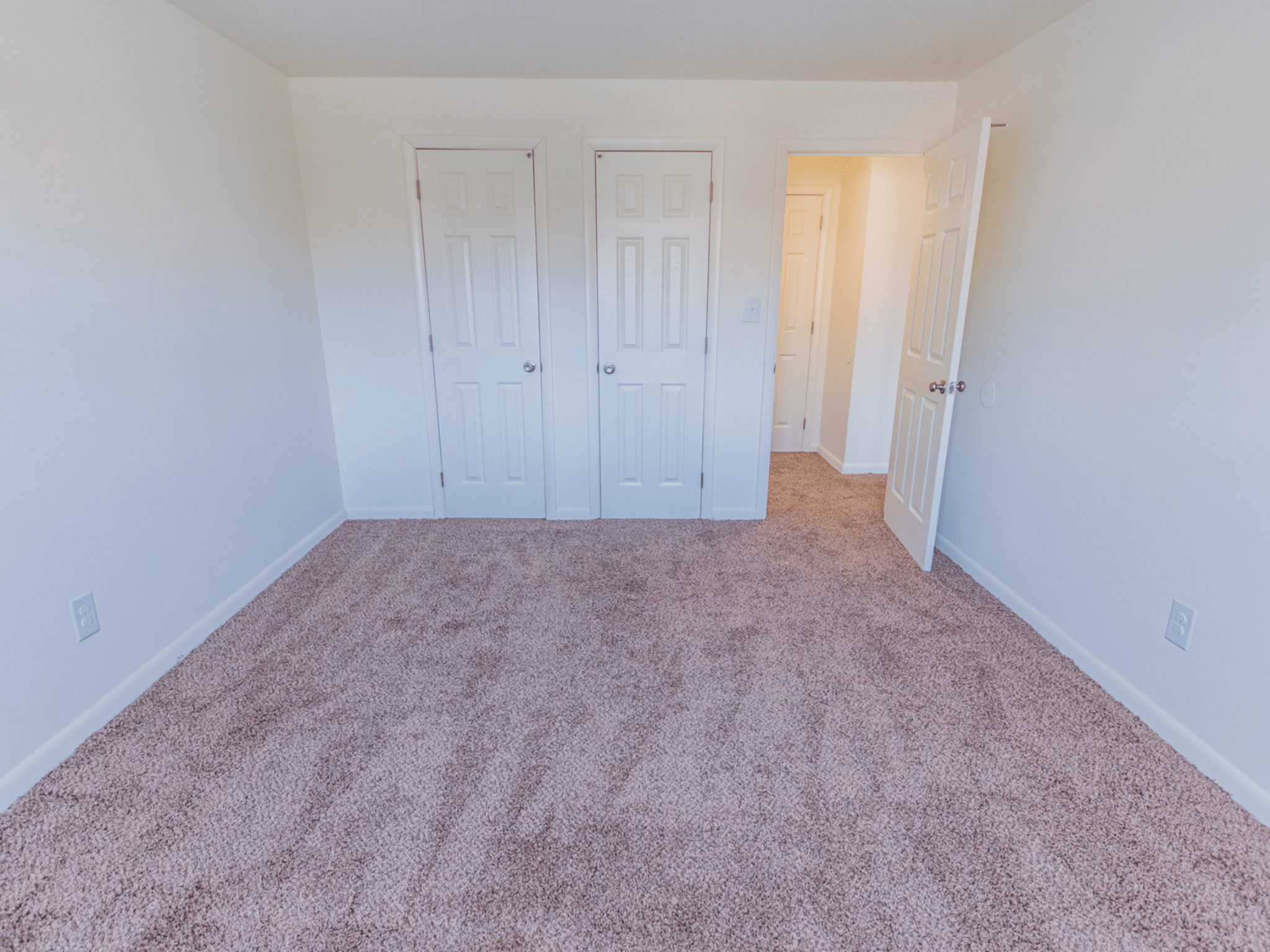 Carpeted bedroom with closets at Polo Ridge Apartments