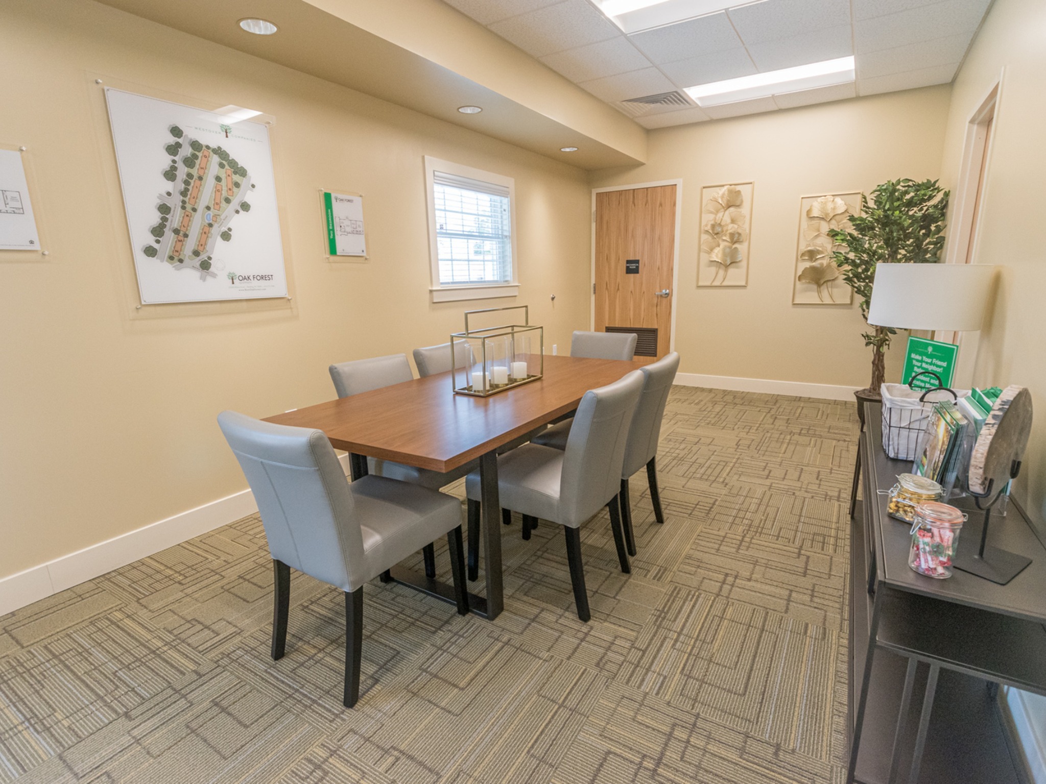 Oak Forest apartments community room area, fitted with a table and chairs, and carpet flooring