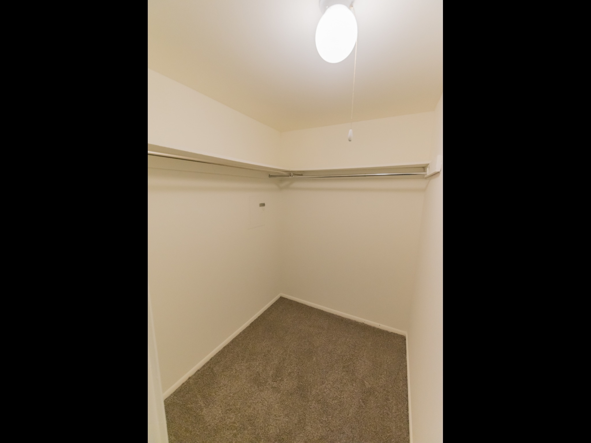 Walk-in closet with a ceiling light.