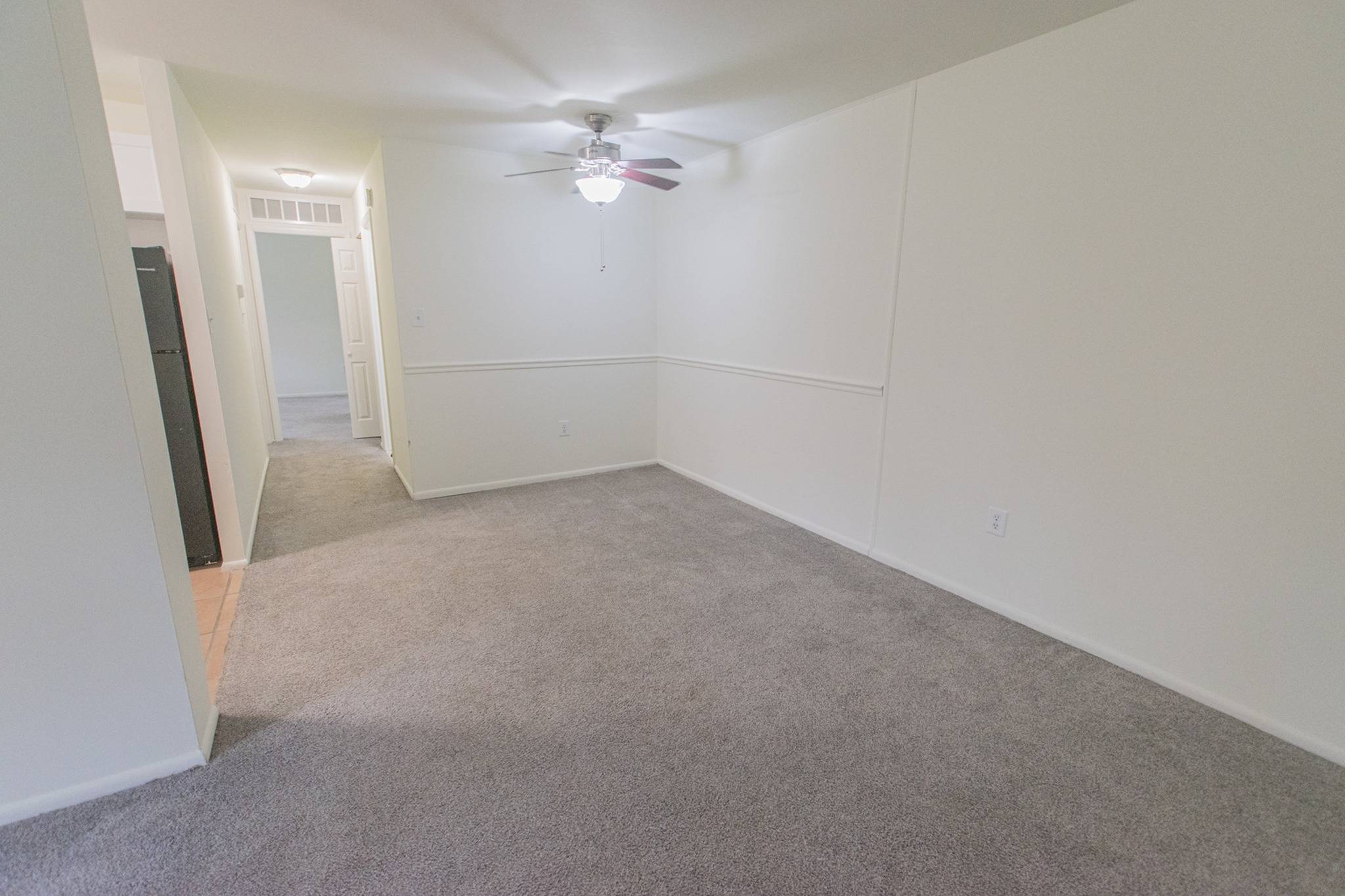 Carpeted area with a ceiling fan.