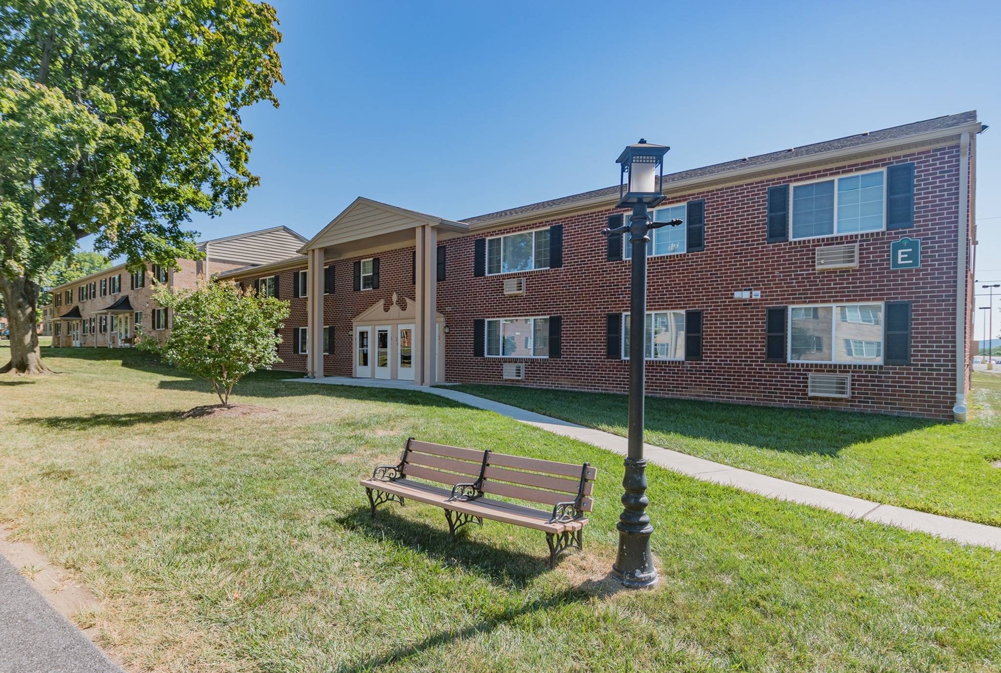 Woodland Plaza Apartments exterior with a pathway leading to apartment entrance